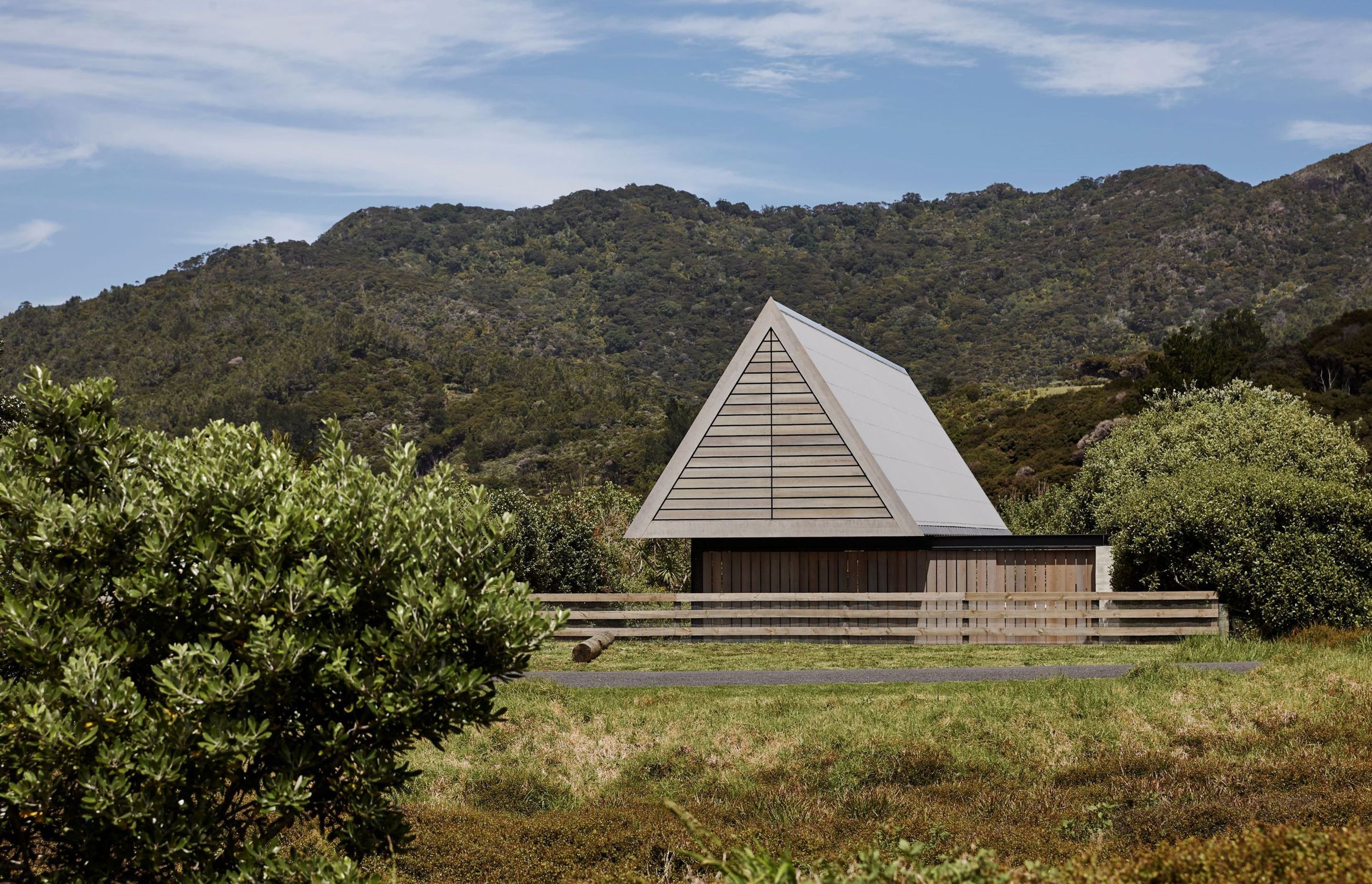 The holiday home sits between the sand dunes on Medland's Beach and the mountain behind.