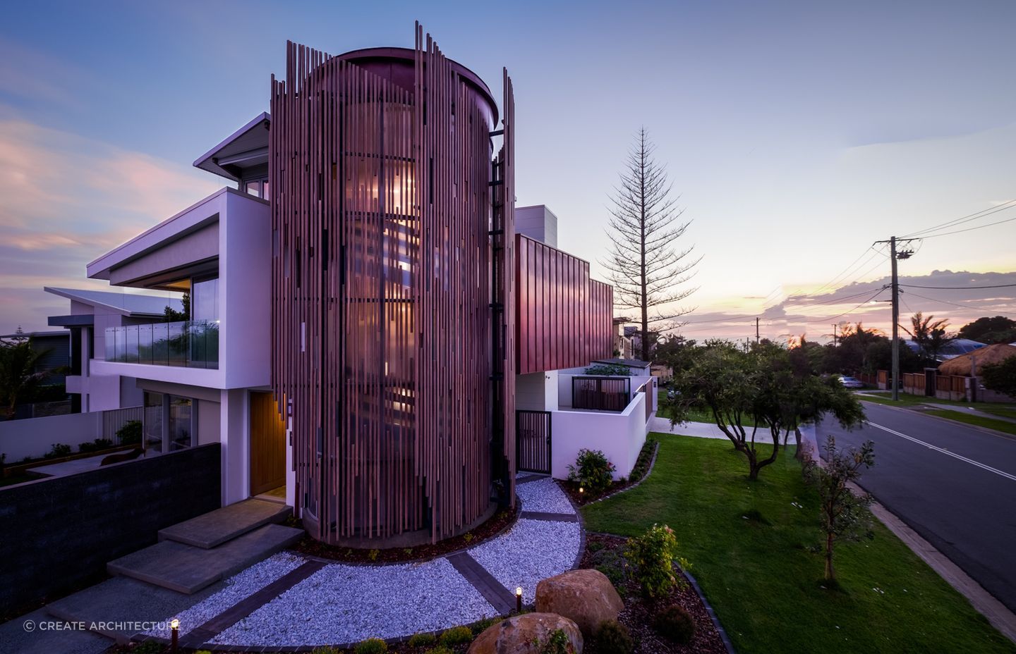 The wooden slats encasing the staircase act as a dramatic light filter.