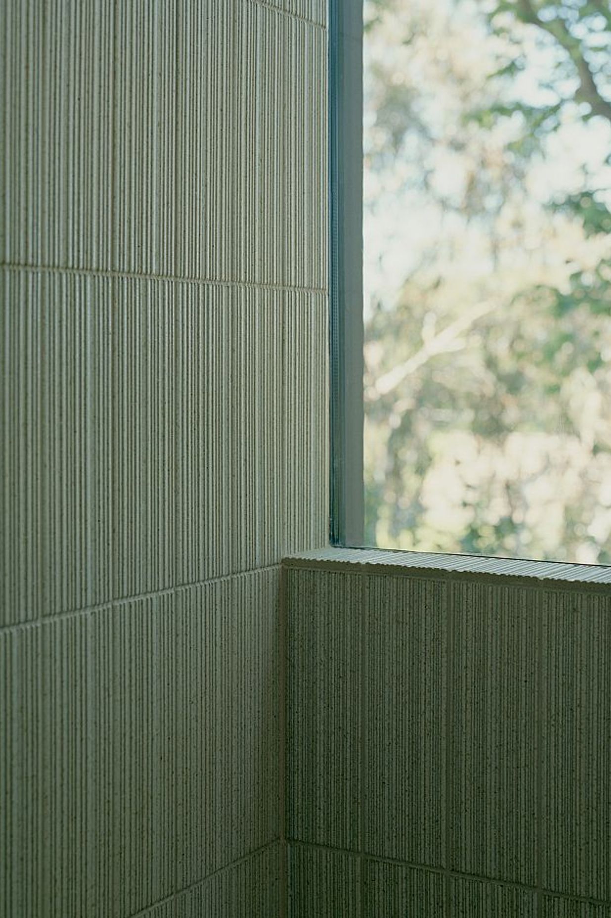Custom INAX Akai ribbed, bush-hammered and glazed tiles on bathroom wall with INAX Akai ribbed, bush-hammered, glazed and sandblasted tiles on bathroom floor. Kew Residence by John Wardle Architects