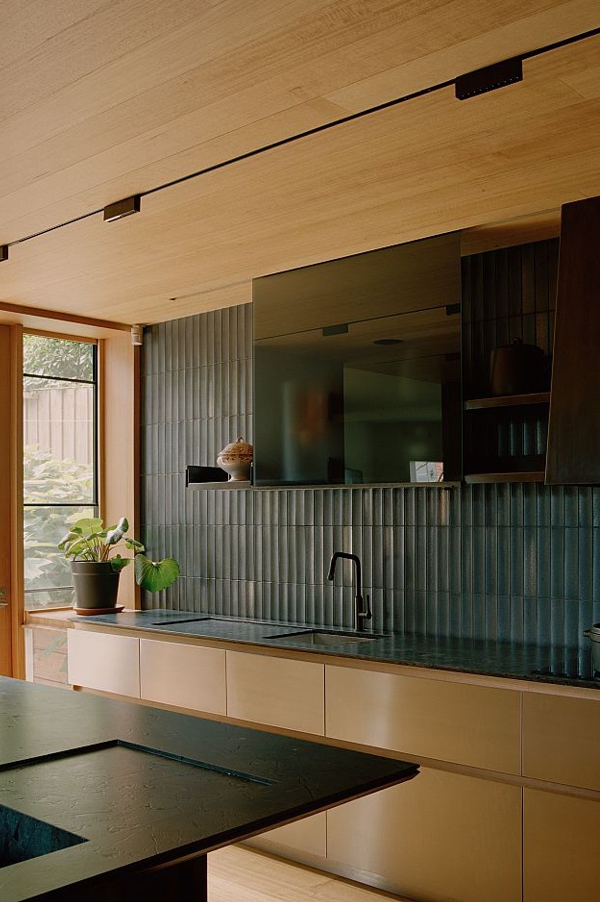 Custom Wakai Tajimi scalloped tiles on kitchen wall. Kew Residence by John Wardle Architects