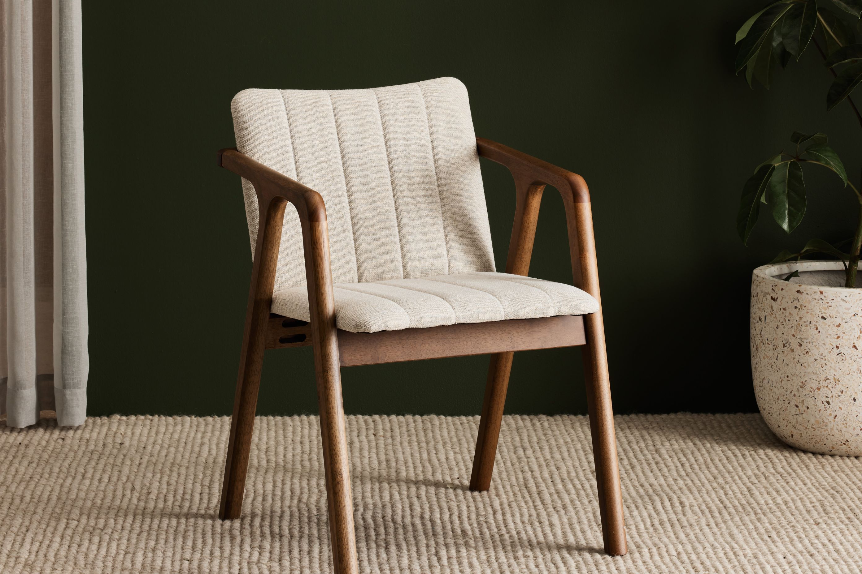 The Elm walnut hardwood dining chair is constructed from responsibly sourced solid timber and eco-friendly beige upholstery.