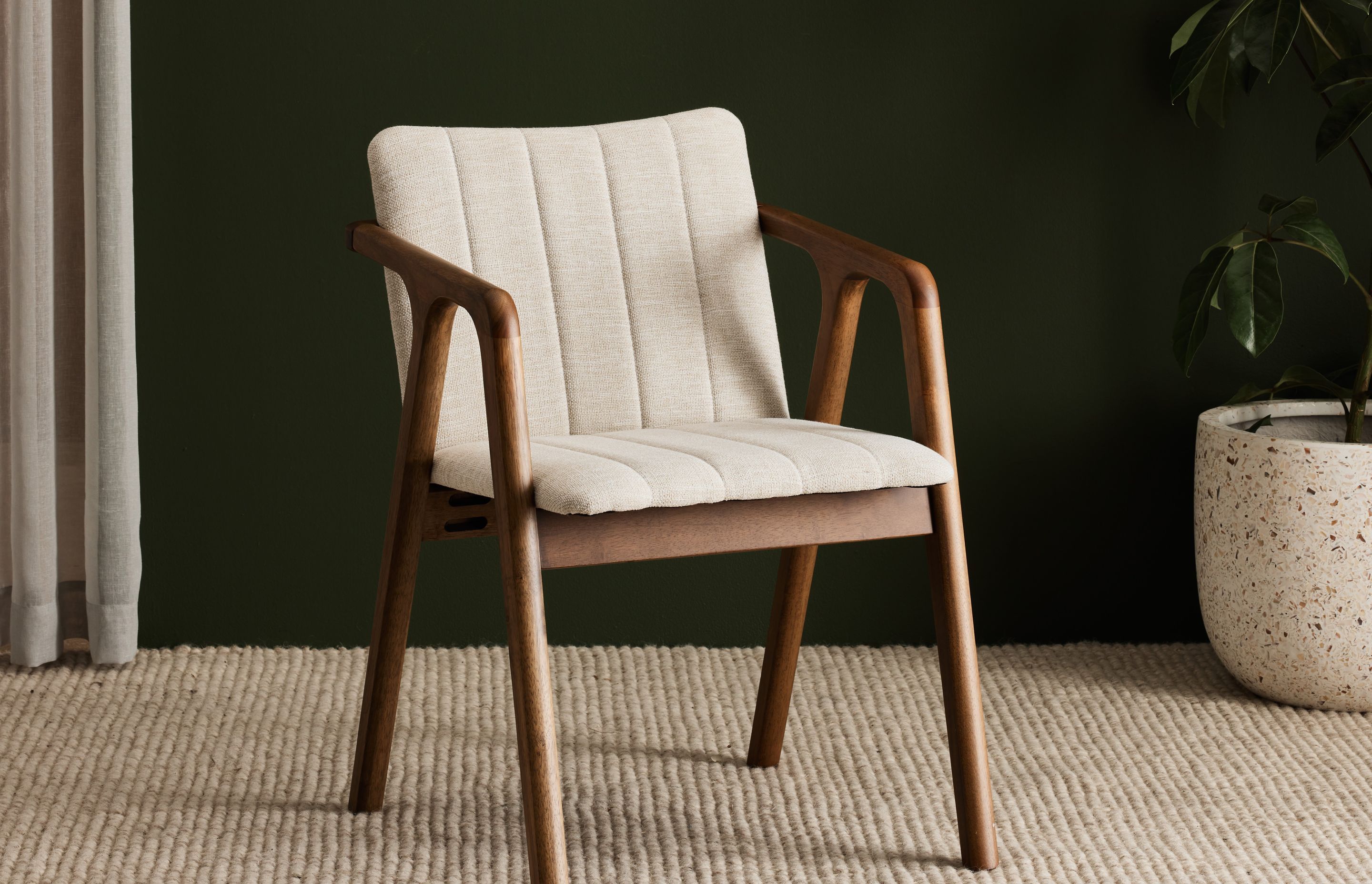 The Elm walnut hardwood dining chair is constructed from responsibly sourced solid timber and eco-friendly beige upholstery.