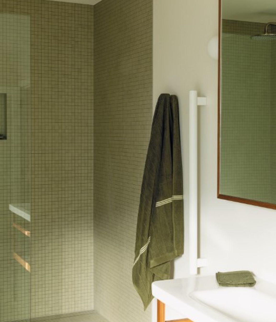 BATHROOM Here, a leggy DuraStyle vanity by Durafit is teamed with Milani tapware from ABI Interiors. The ceramic wall and floor tiles from Artedomus have a matte finish that Bailey sought to sync with the look of the Oasis freestanding bath by Concrete Nation, and the walls are in Porter’s Paints Cashmere to match the other main rooms in the house. On the vanity and Grab 90 rails by Avenir from Plumbline are organic cotton towels by Bailey’s own luxury brand, Baina. Pictured right, a large, frosted-glass window opens like a door to provide maximum ventilation in this space. “In the morning, the sun streams in through it — it’s beautiful,” says Bailey.