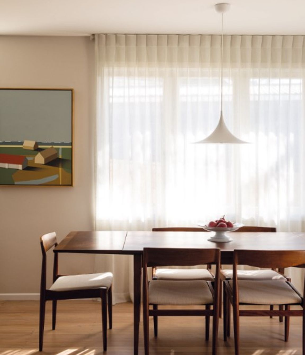 Linen curtains on a curved track provide privacy from the neighbours beside Shores II by Bohdan Burenko on the adjacent wall. The dining table and chairs below the Semi pendant by Gubi were sourced from Mr Bigglesworthy.