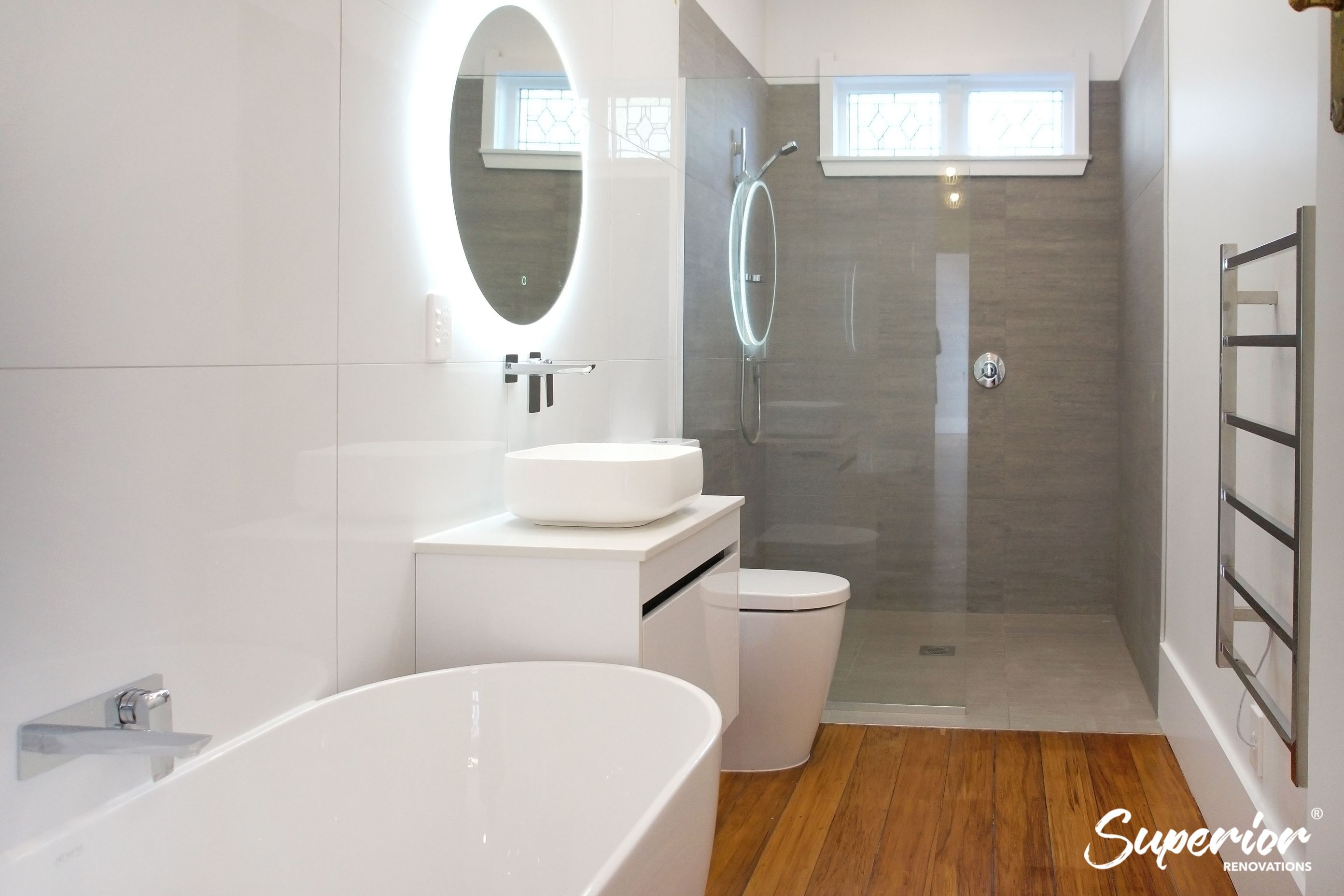 Wet area created at the end of the bathroom which was partially separated by a glass. This narrow bathroom was fully renovated and all fixtures were installed next to eachother to make maximum use of the area.