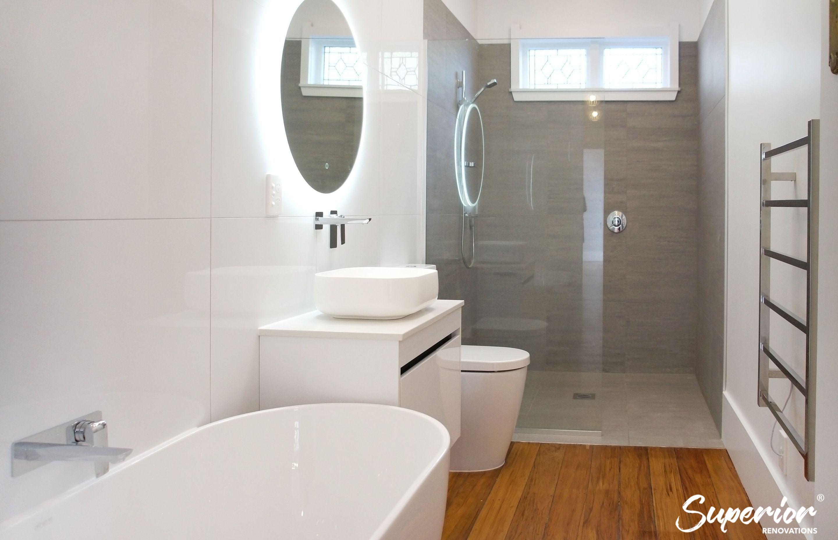 Wet area created at the end of the bathroom which was partially separated by a glass. This narrow bathroom was fully renovated and all fixtures were installed next to eachother to make maximum use of the area.