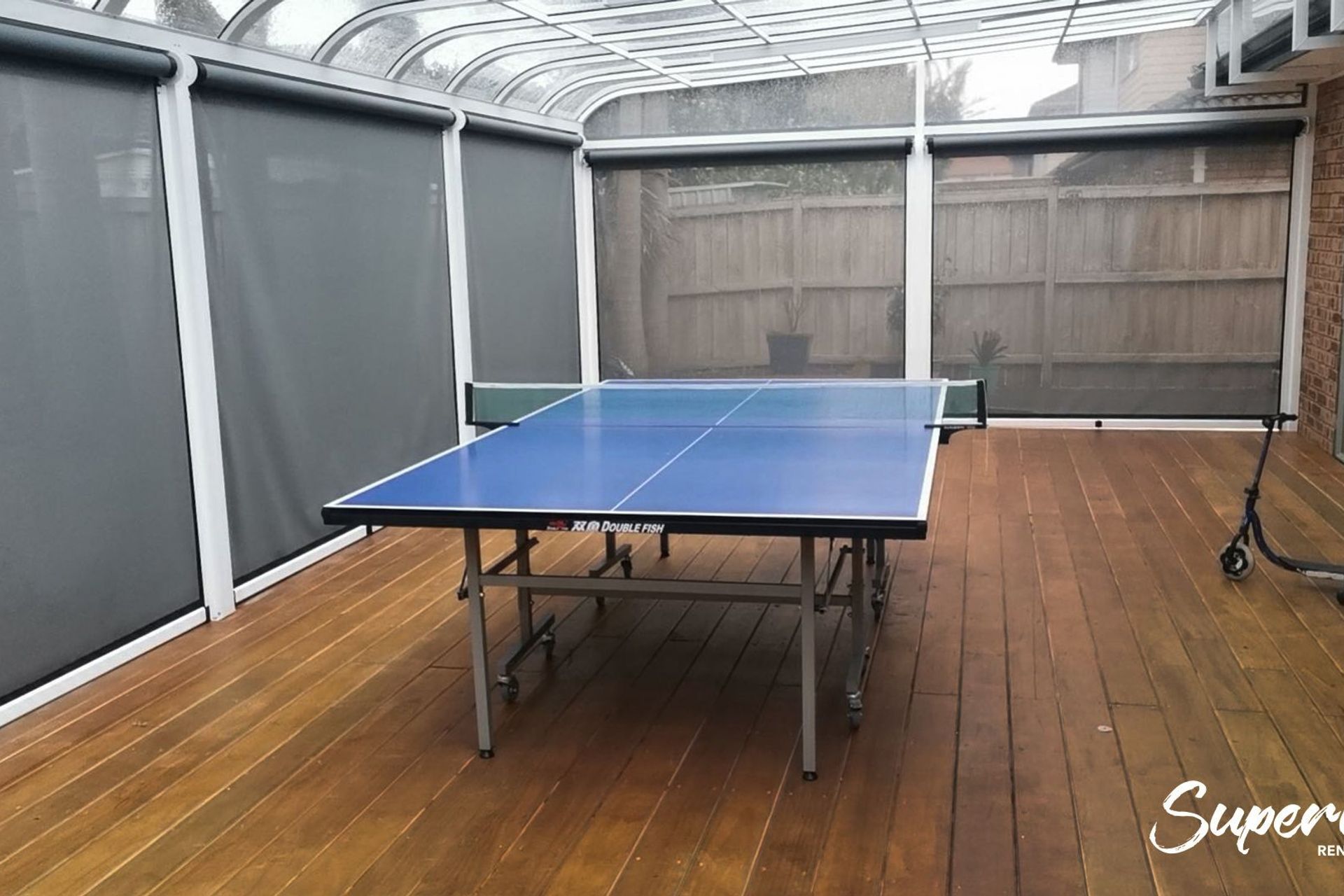 A great entertainment hub with a pool table inside the pergola with blinds