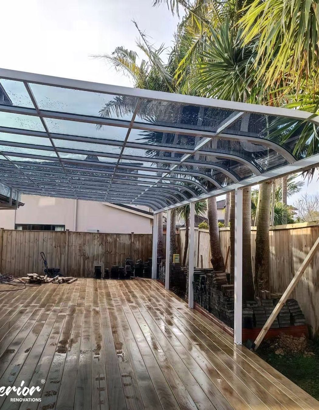 A white custom pergola over a deck with UV protective panels on top