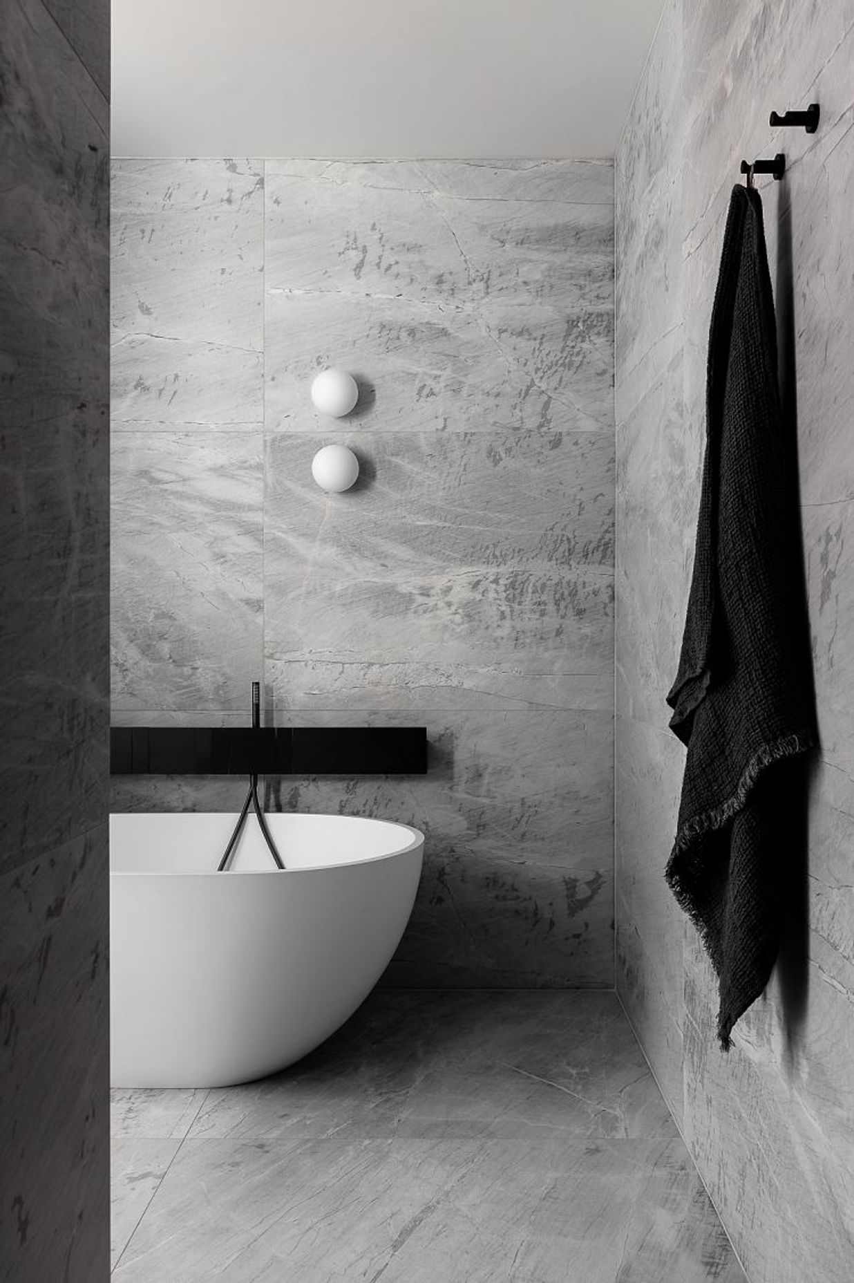 Elba Honed to bathroom floor and walls with Agape Sen tapware and accessories. Scalpellino House by Biasol. Photography by Timothy Kaye