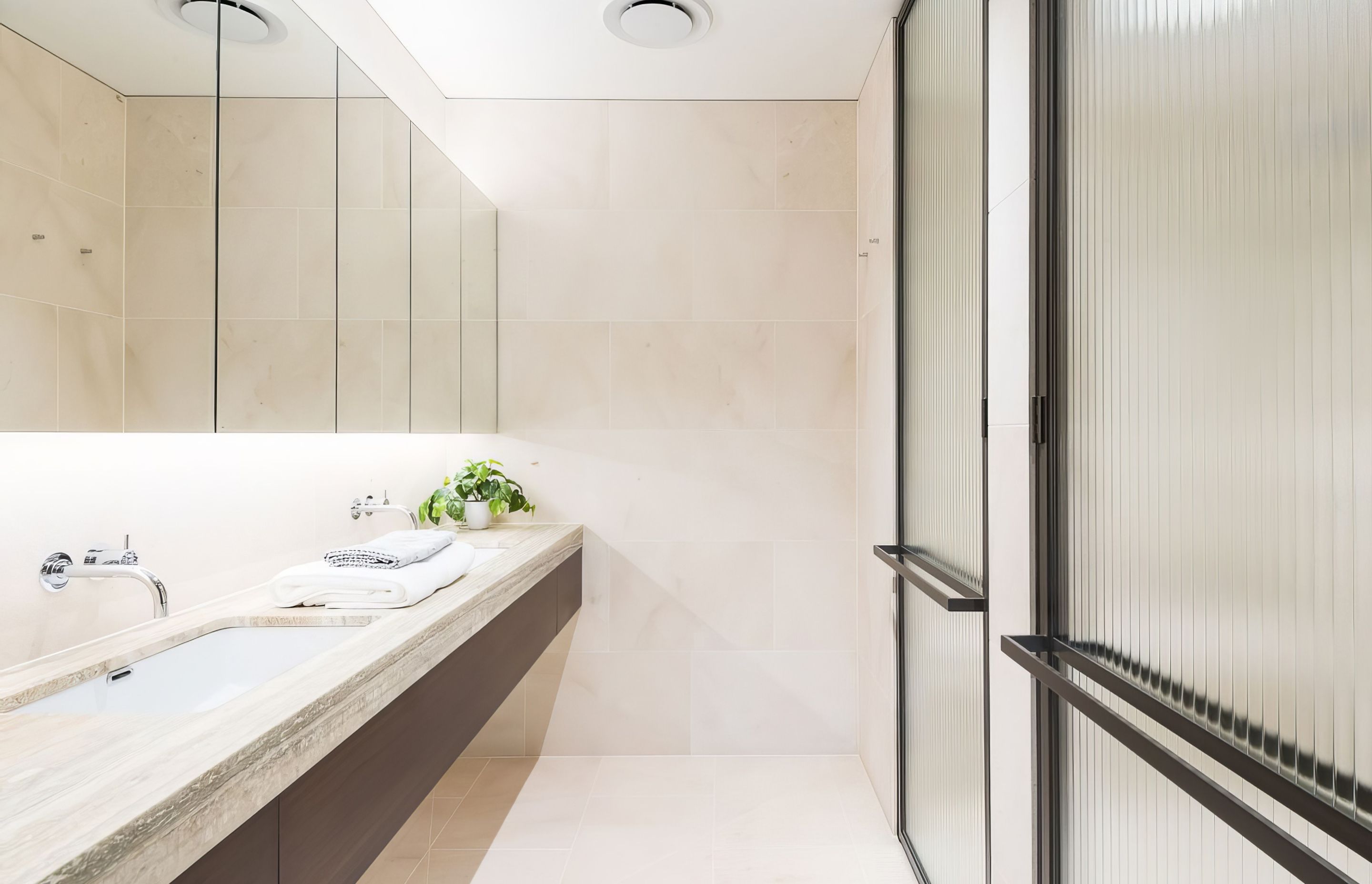 Rocca Bianca honed floors and walls with Ocean Blue Travertine vanity top. Barker, New Farm by Pike Withers