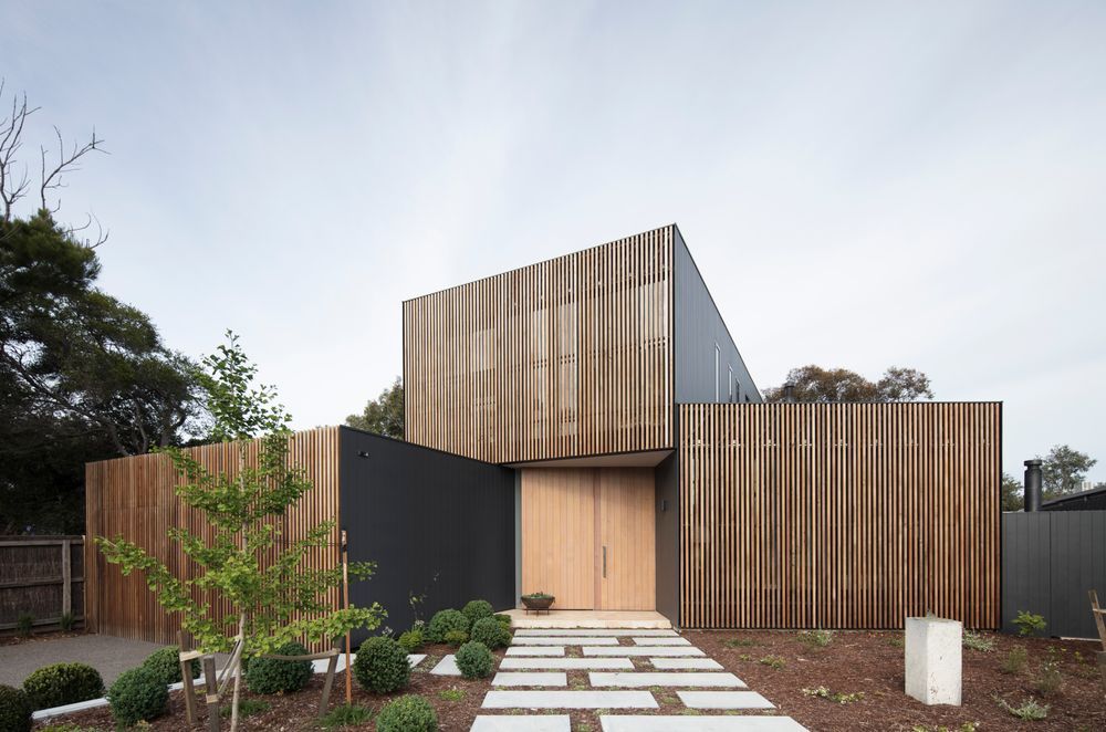 This home's facade mixing Western Red Cedar screens with a matte black metal finish creates a unique visual identity. Photography: Ben Hosking