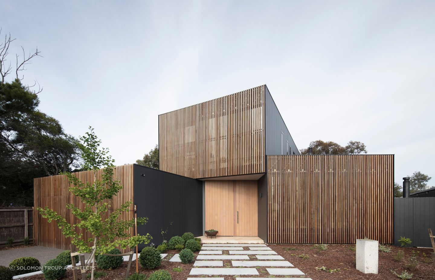 This home's facade mixing Western Red Cedar screens with a matte black metal finish creates a unique visual identity. Photography: Ben Hosking