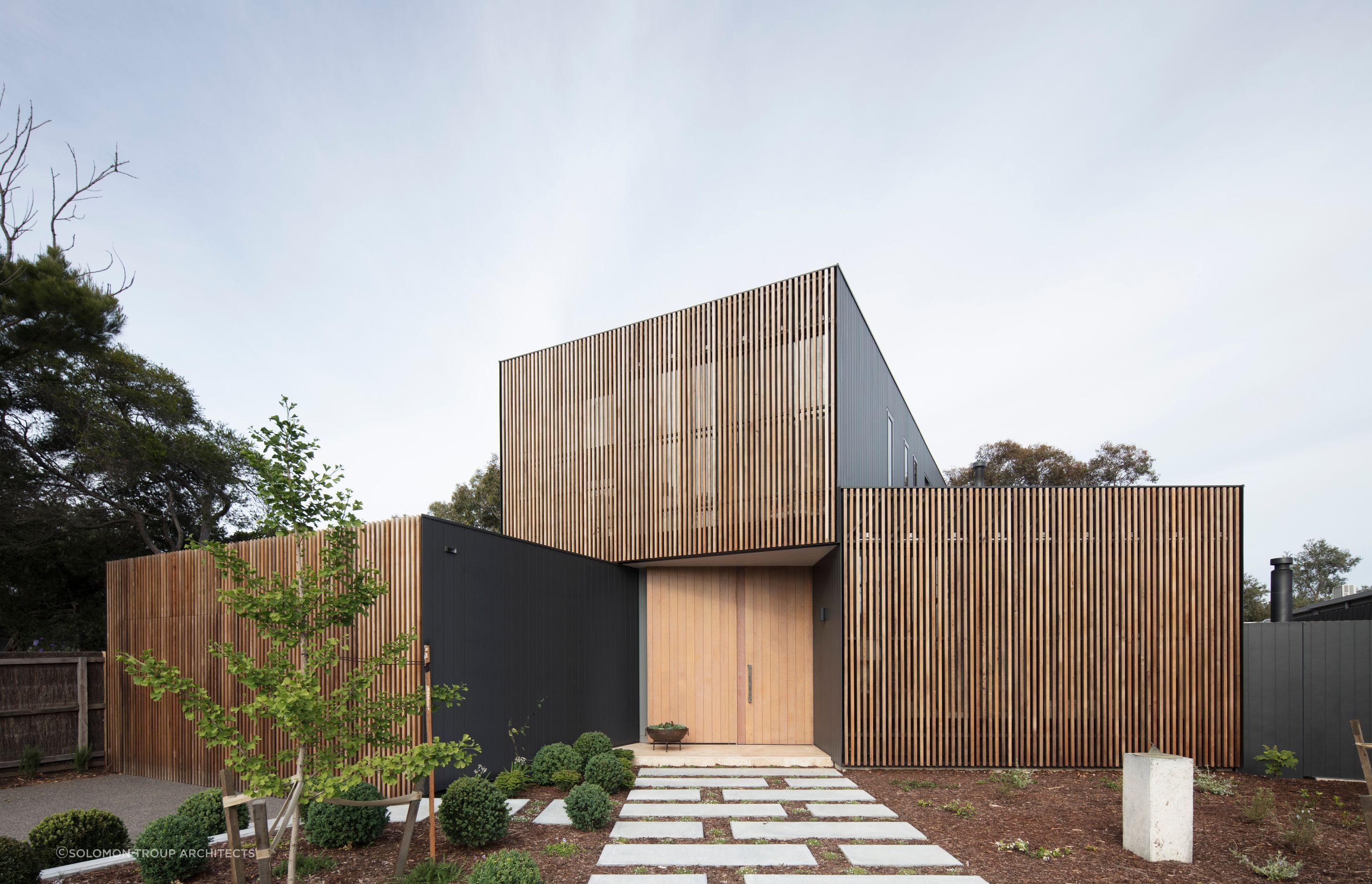 This home's facade mixing Western Red Cedar screens with a matte black metal finish creates a unique visual identity. Photography: Ben Hosking