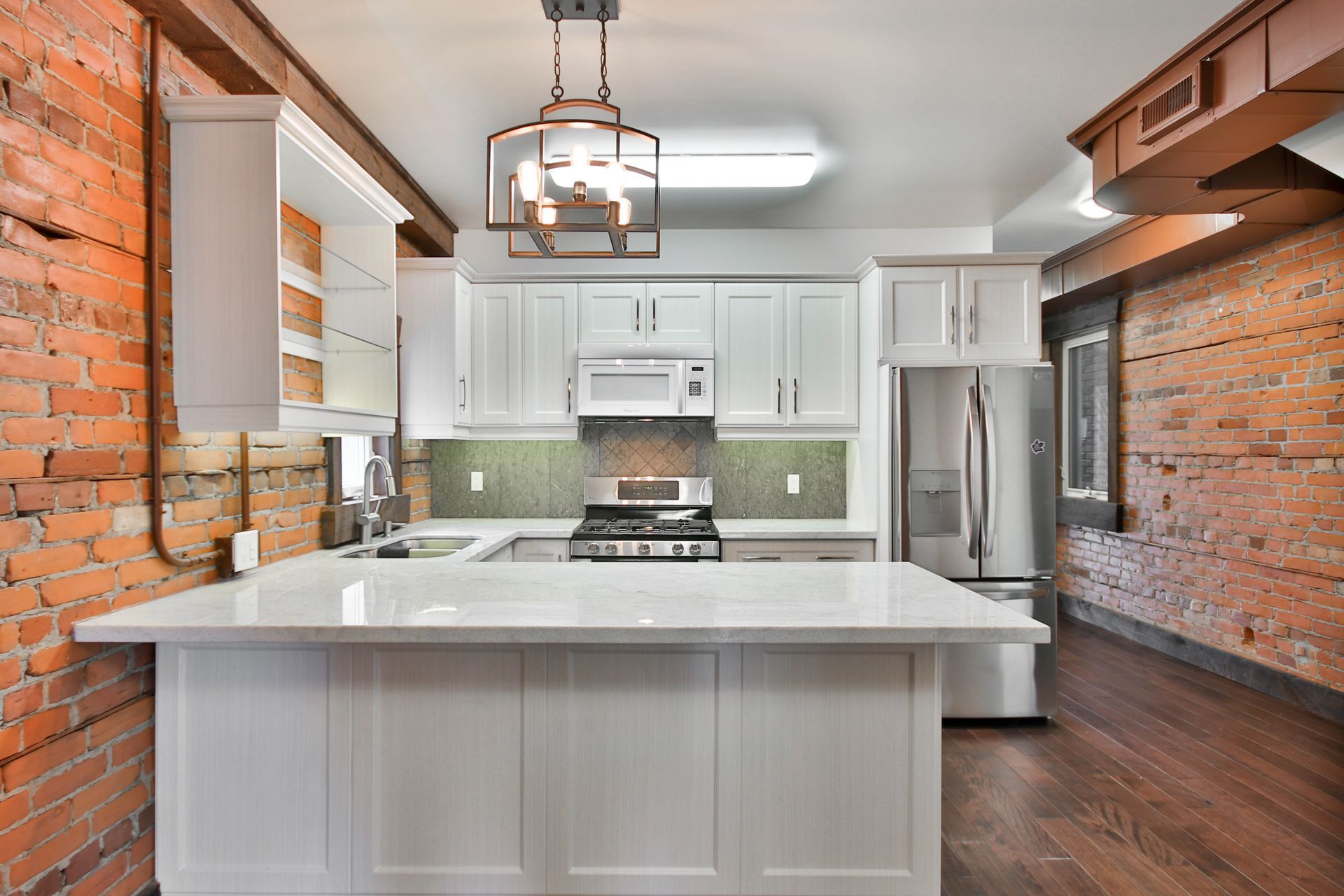 Exposed Brick on opposite walls give this relatively classic kitchen an industrial feel