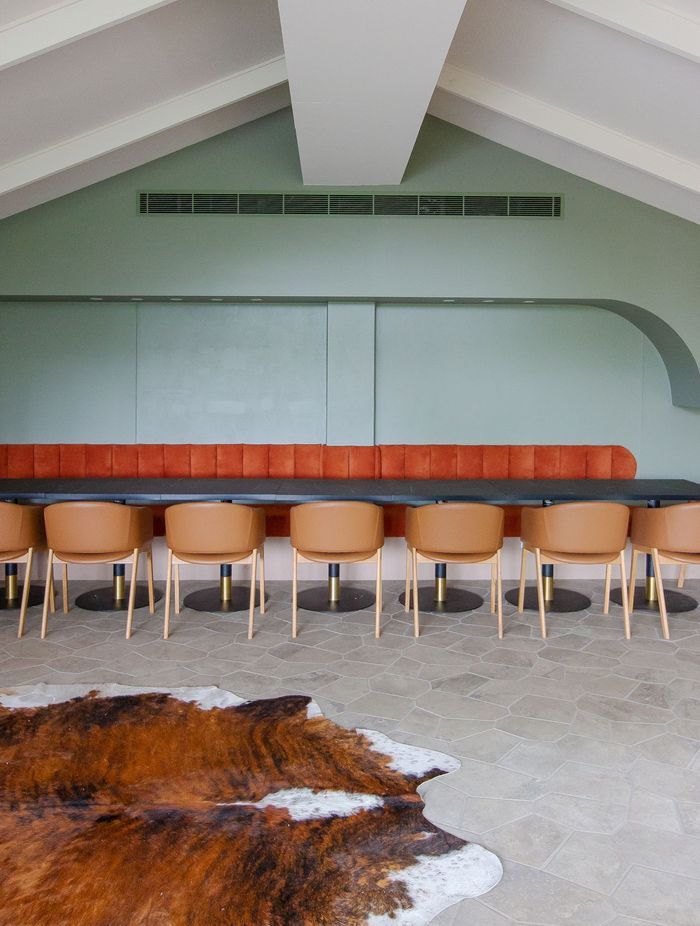 A spacious dining room featuring large-format floor tiles designed with fewer grout lines, creating a seamless and visually expansive surface