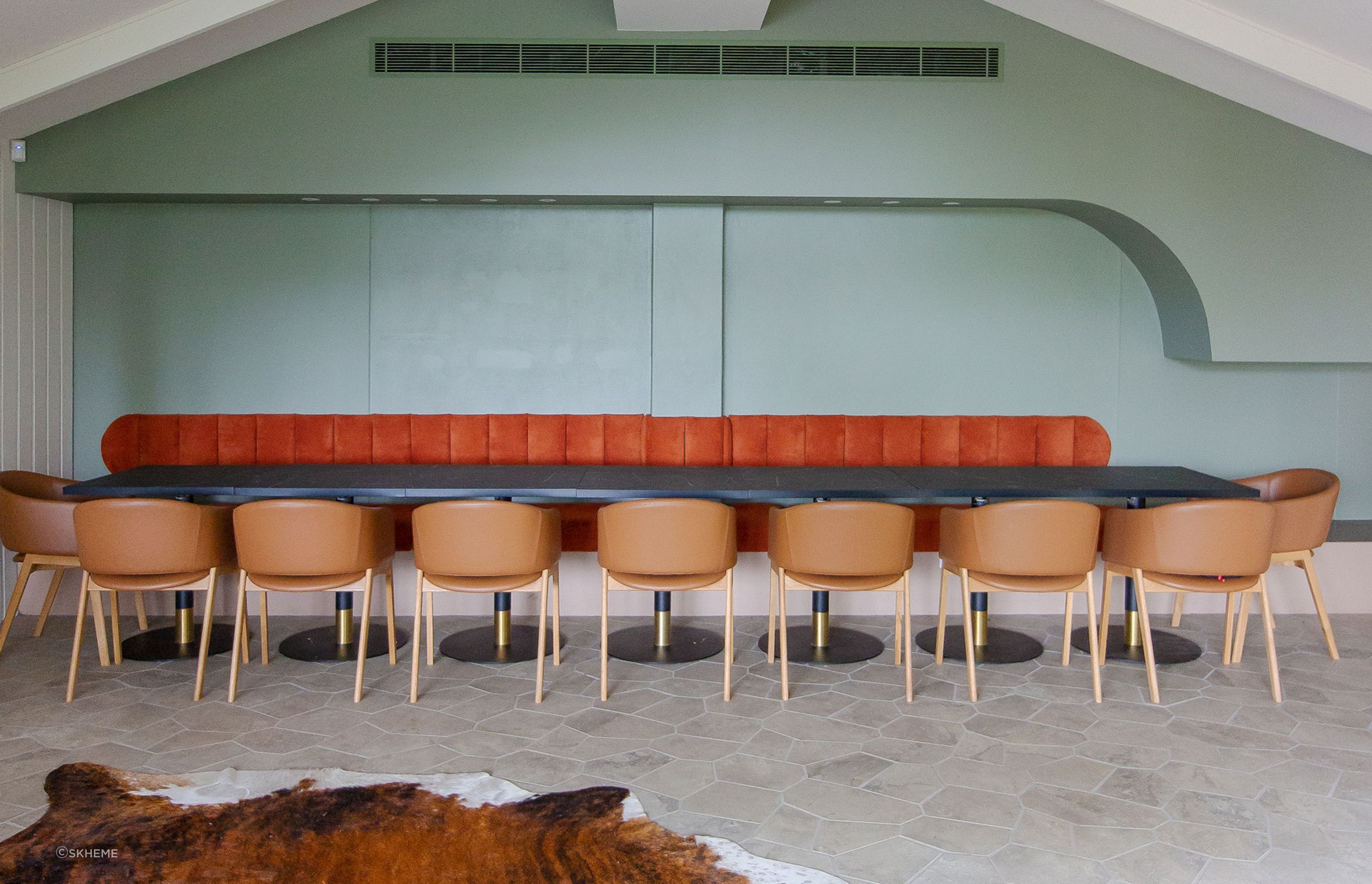 A spacious dining room featuring large-format floor tiles designed with fewer grout lines, creating a seamless and visually expansive surface