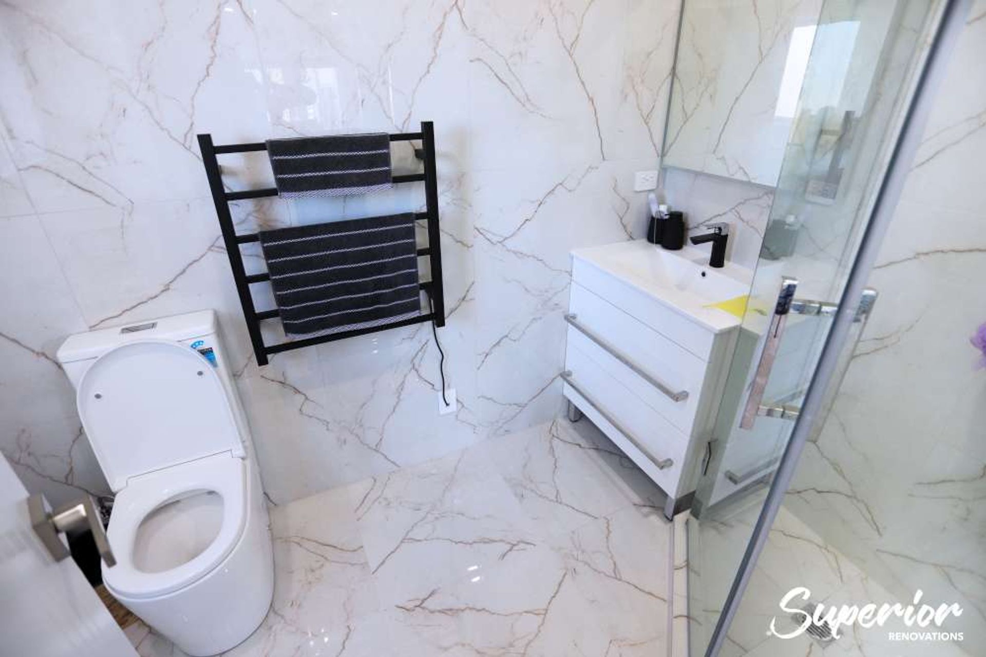 This was a very small awkward place but our clients wanted to make this a guest ensuite. We used the corner L shaped area to make a tiled glass door shower. The same times were used on the walls and floors to give an illusion of space – Bathroom renovatio