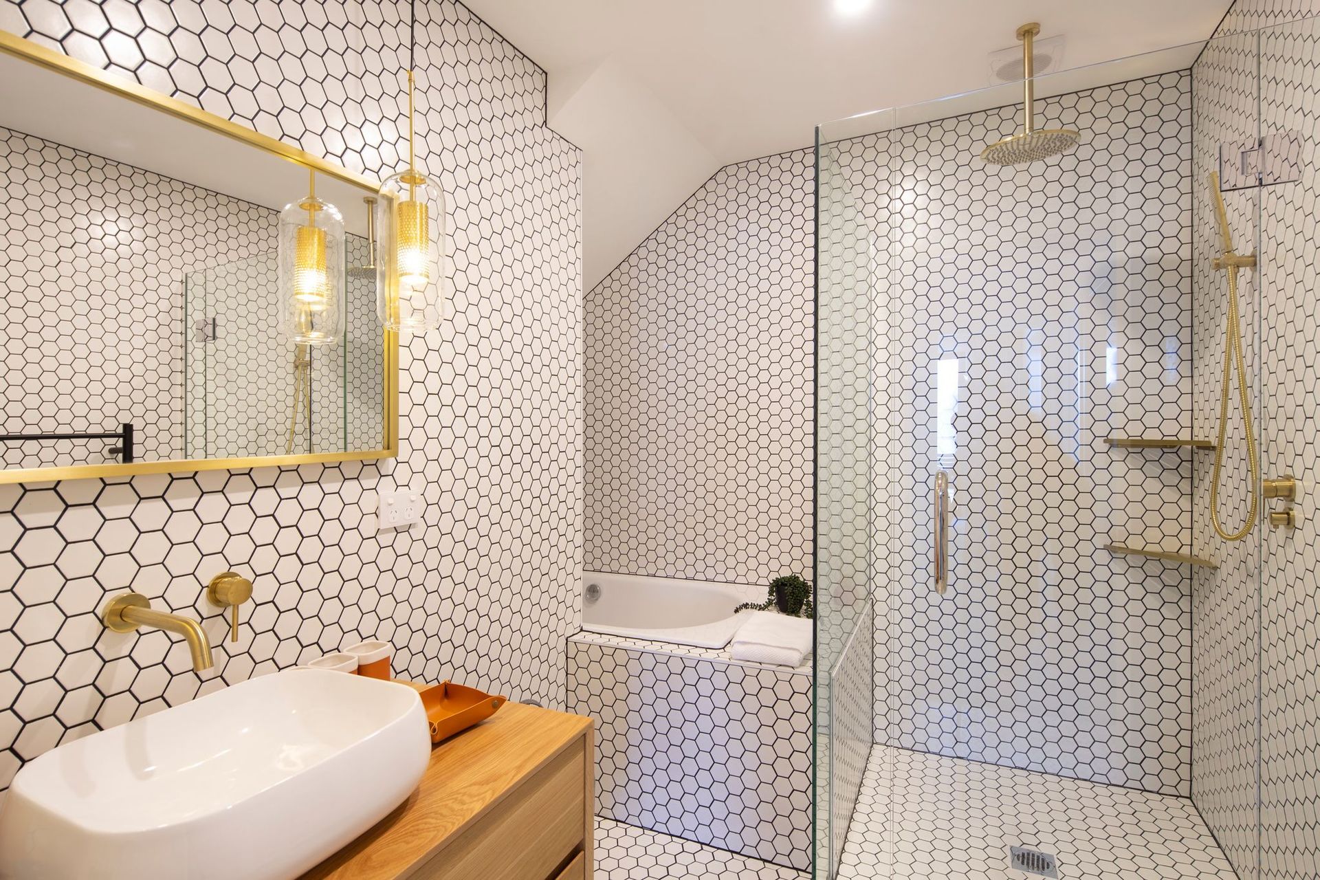 Mosaic tile bathroom styling from floor to walls and bathtub surrounds create an eye-catching aesthetic.