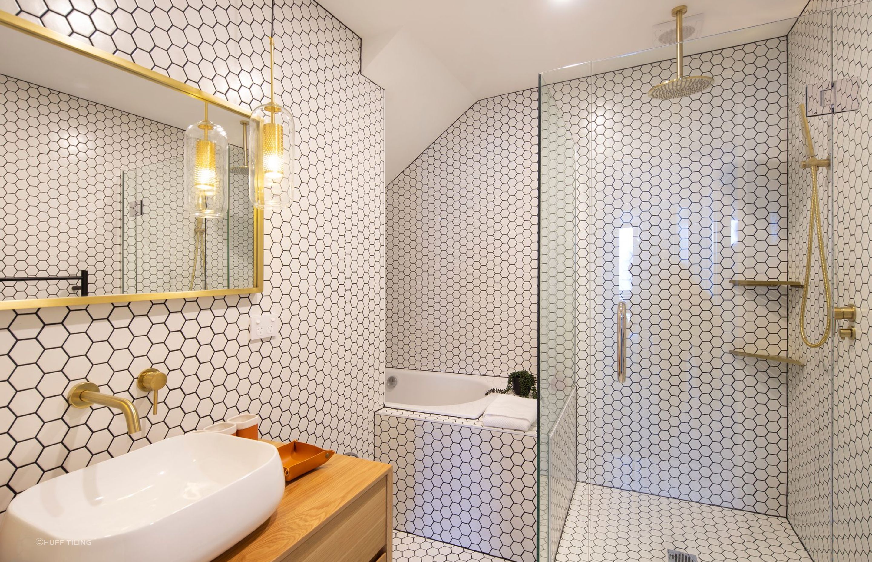 Mosaic tile bathroom styling from floor to walls and bathtub surrounds create an eye-catching aesthetic.