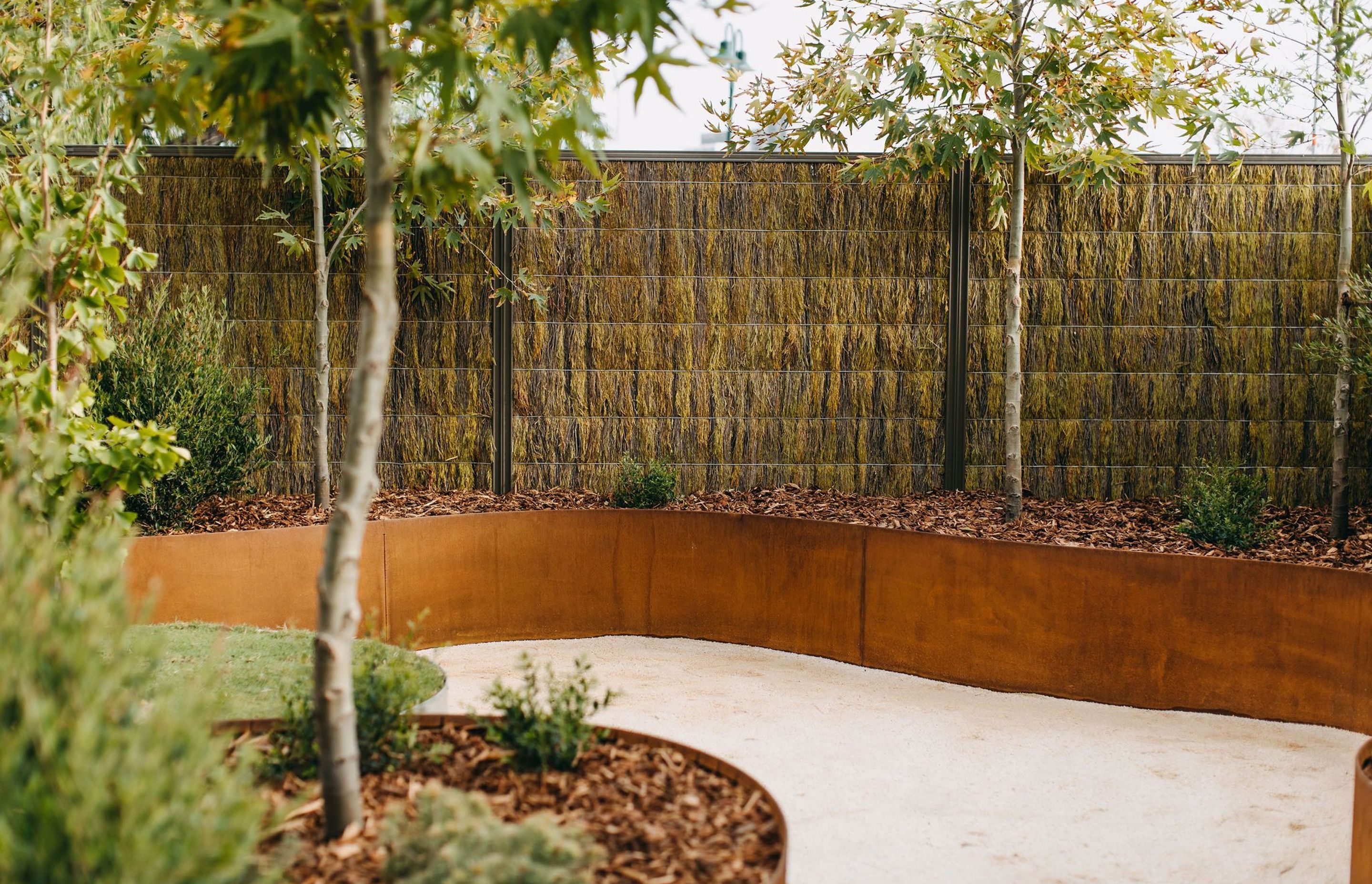 Straightcurve's range of flexible garden edging, retaining walls and modular planters—available in weathering steel and galvanised steel—has made it possible to create self-bracing, free-form curved garden beds.