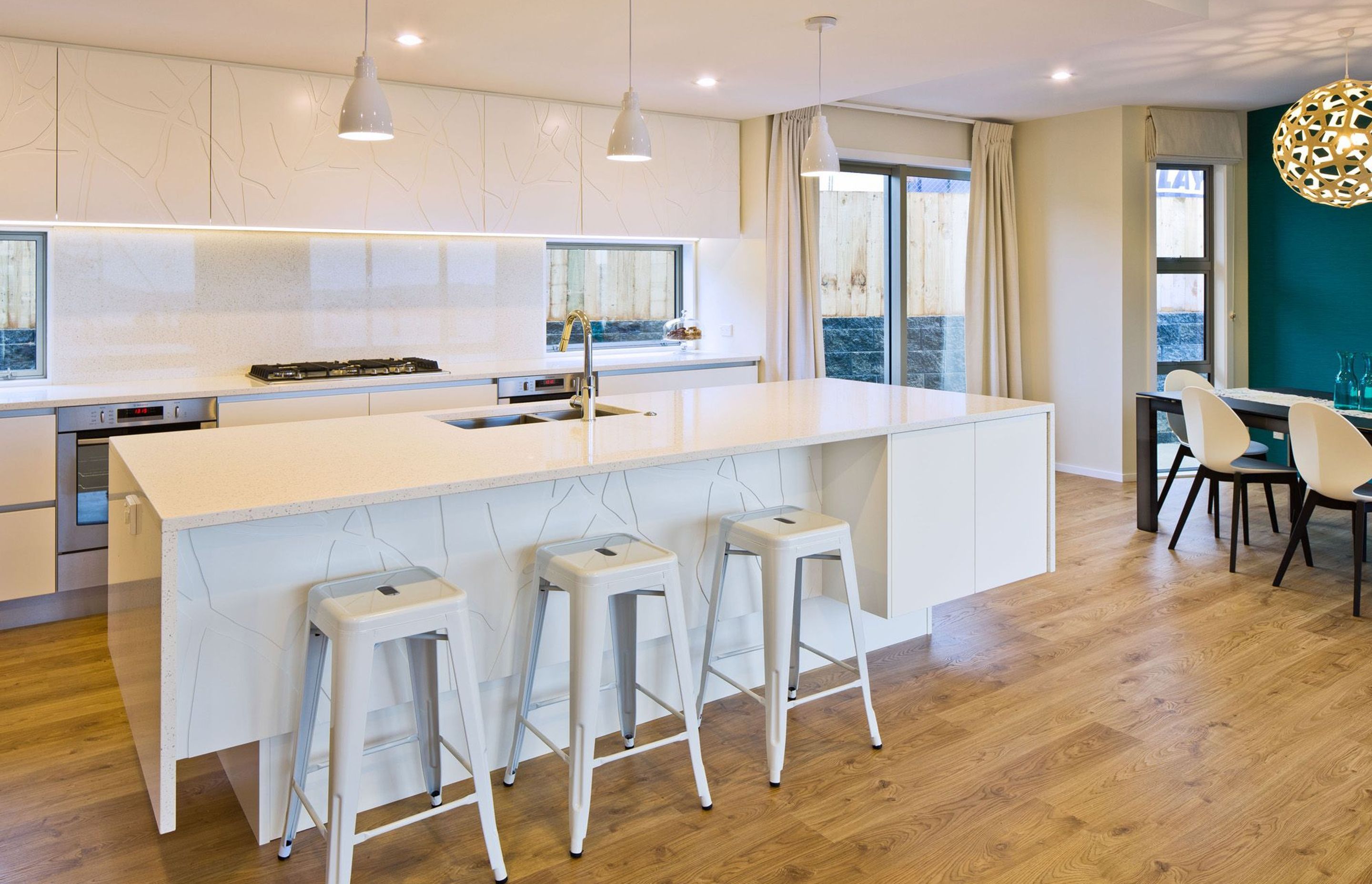 To bring something unexpected to this white kitchen, Simone worked with the joinery team to add a unique tree pattern to the cabinetry – adding textural interest.