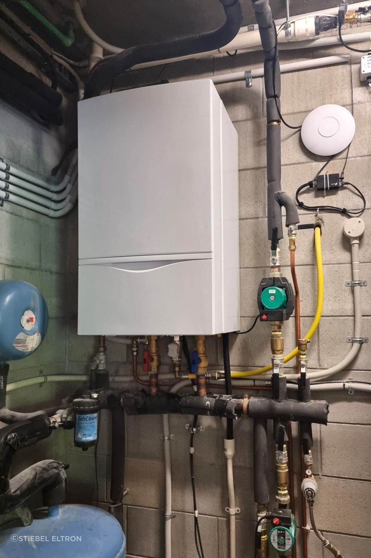 An existing gas boiler for underfloor, spa, and potable water heating.