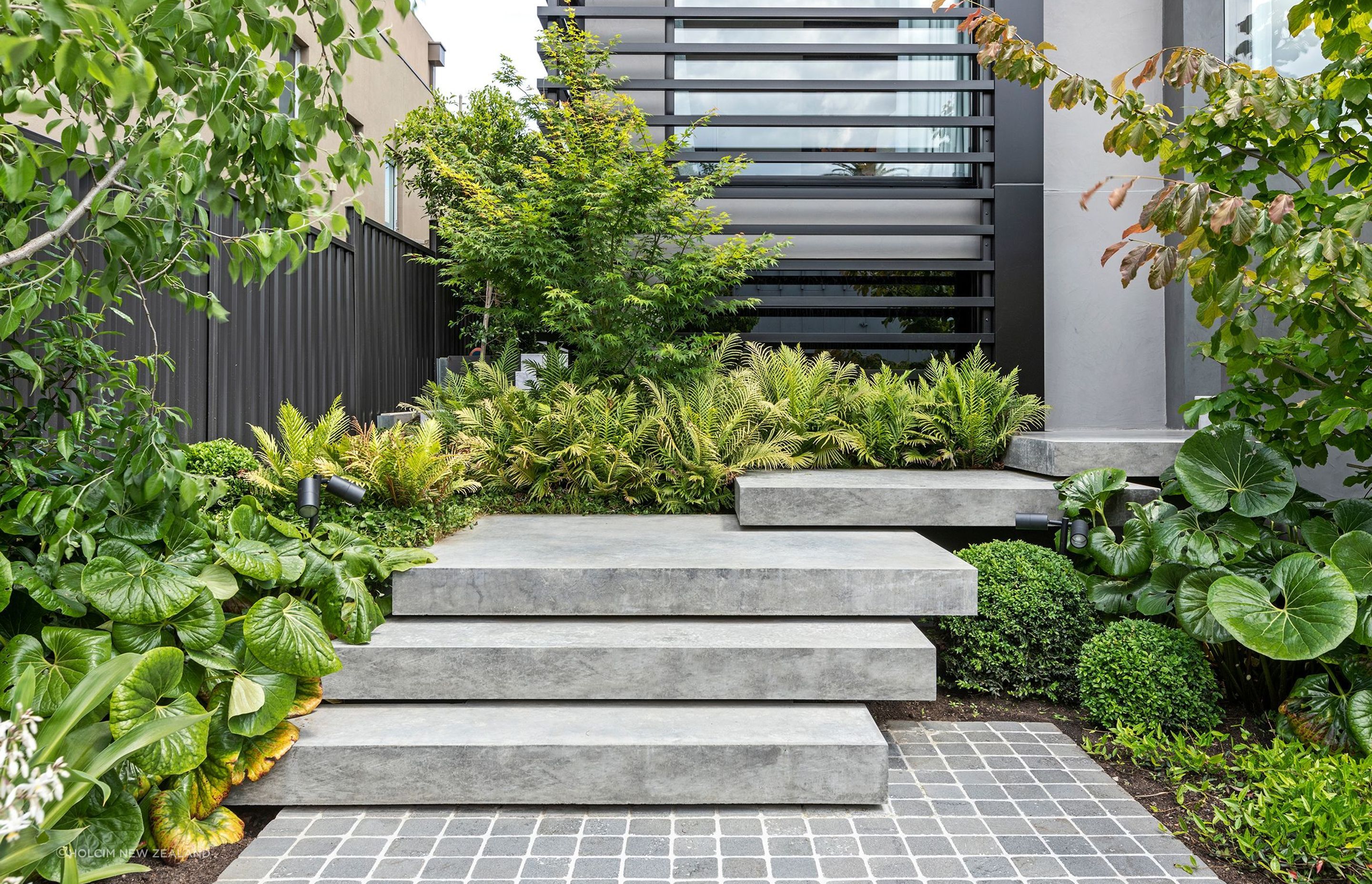 Designed for beauty and durability, Holcim's new decorative concrete range, featuring 12 contemporary colours, provides a high-quality appearance and a practical alternative to paving, asphalt, marble, or timber. Image: Geostone Project at Antares Court.