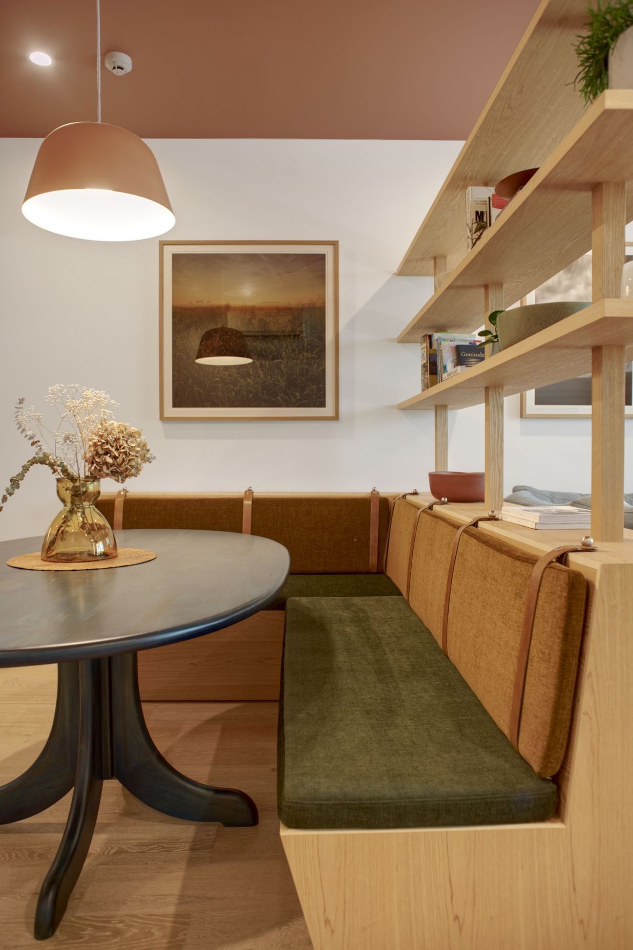 A tiered shelf with integrated custom-made bench seating separates the dining and lounge area | Photography by Ben Rowsell