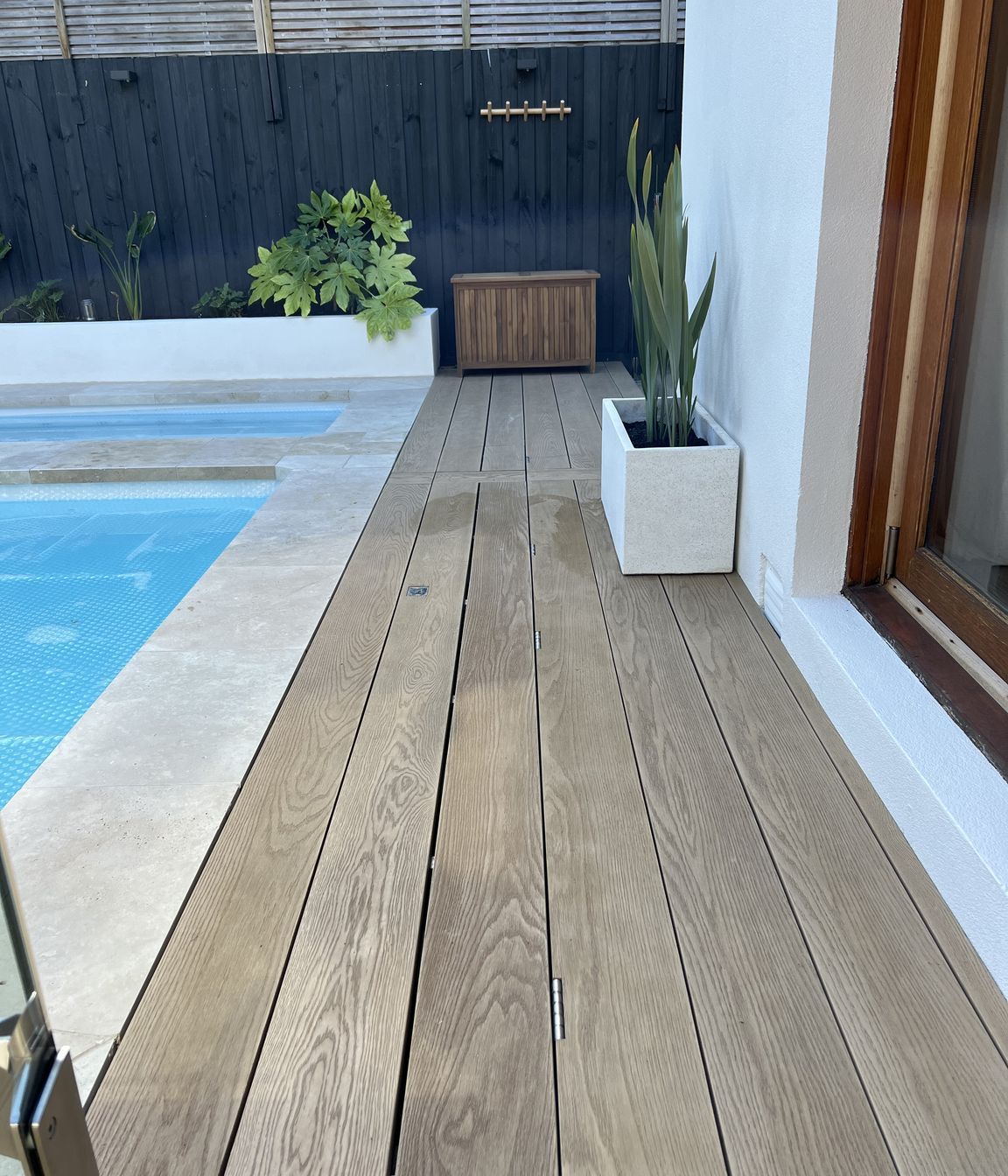 This timber decking pool cover is so seamless, it's practically invisible.