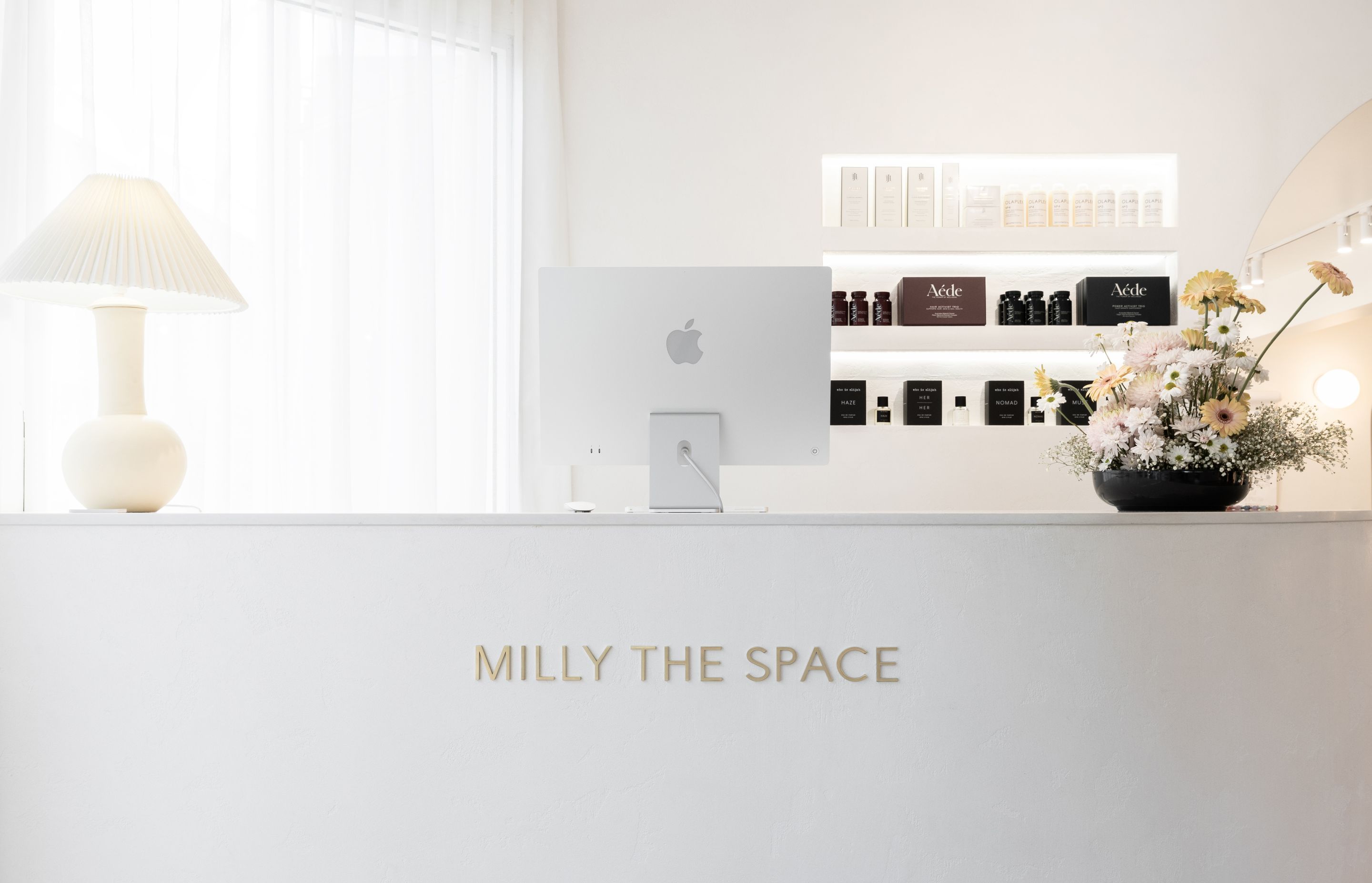 Elegant lettering used on the reception desk at hairdressing salon Milly The Space in a brushed brass finish.