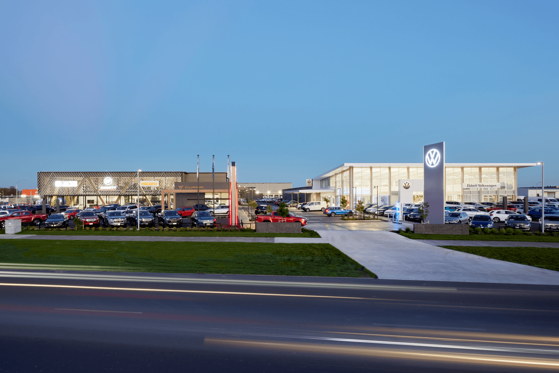 The two dealerships are unified by the tree-lined boulevard between them.