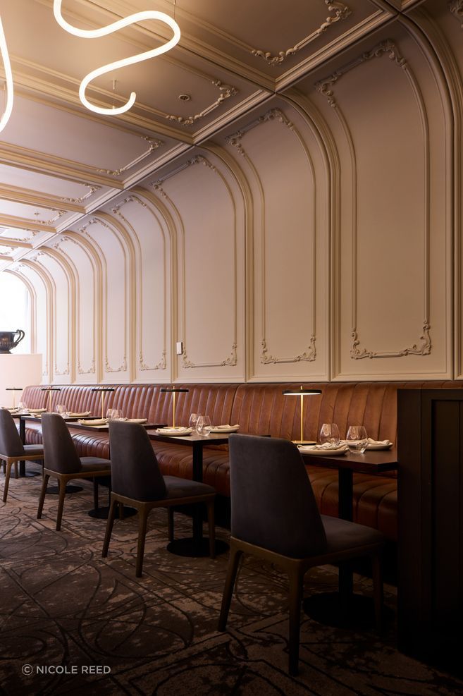 Art Nouveau panelling curves from the wall to the ceiling.