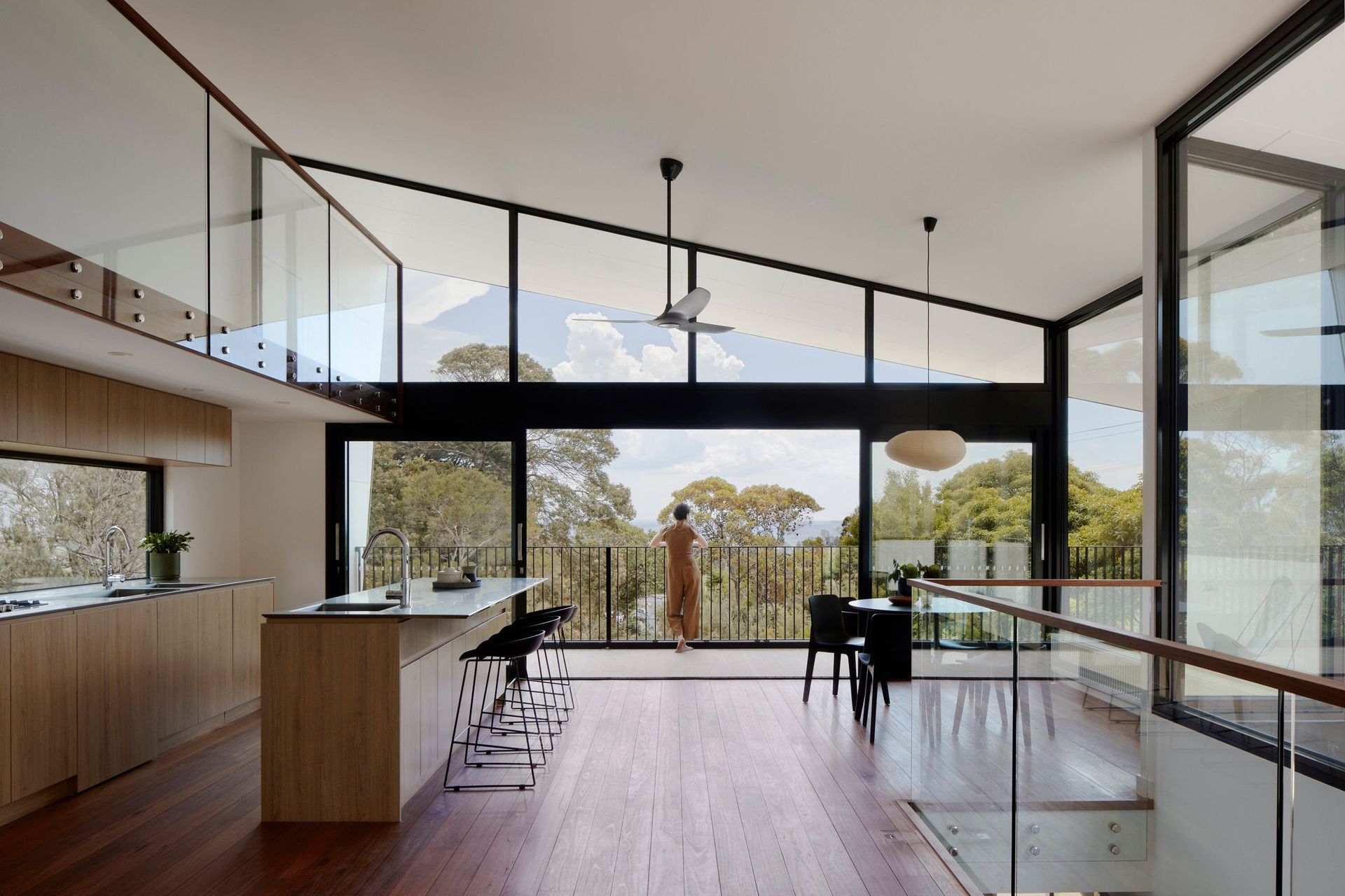 Floor-to-ceiling glazing captures the outlook across the bush landscape and out to the water.