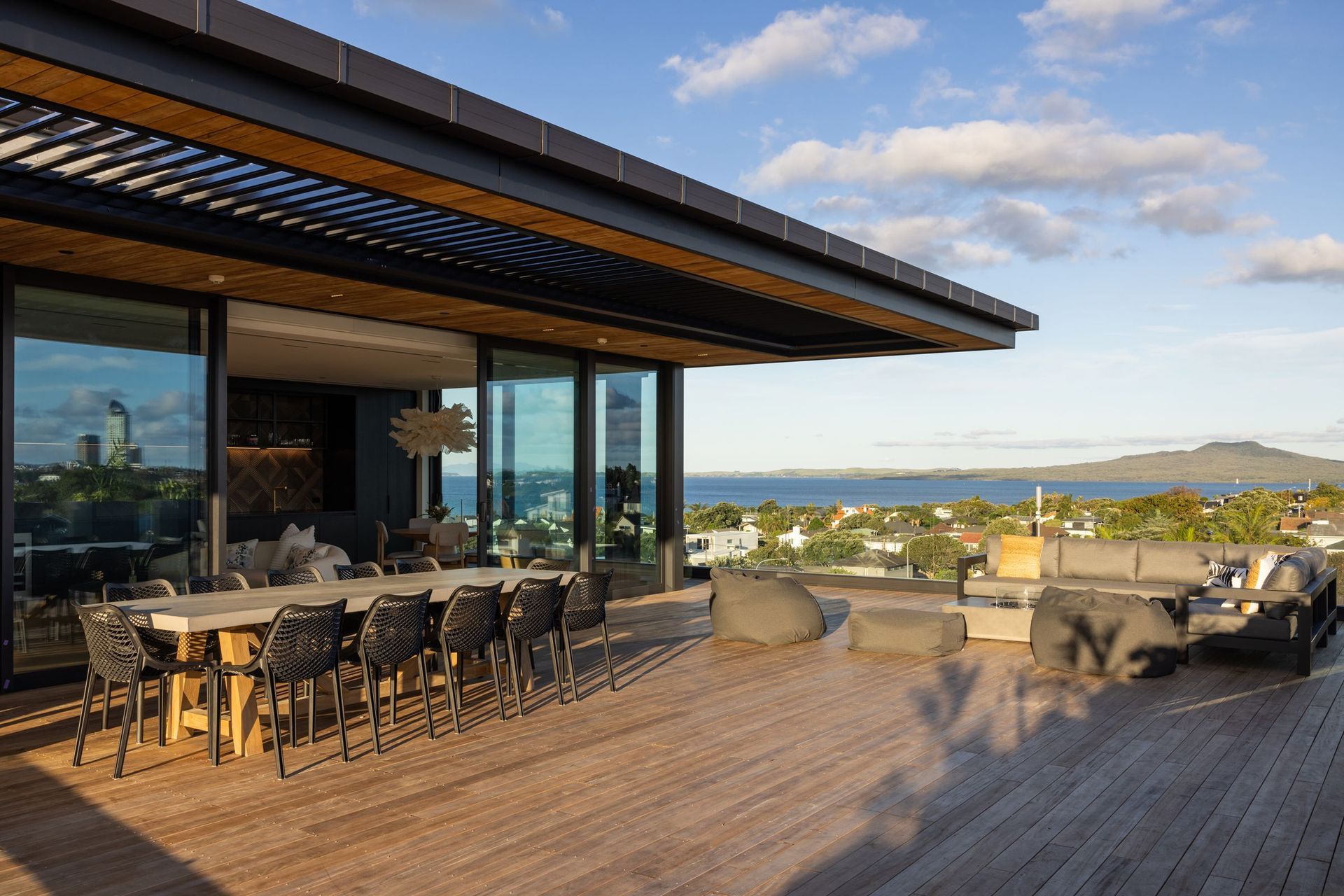 The deck is complete with plenty of seating, a fire pit, and a breathtaking view of Rangitoto.