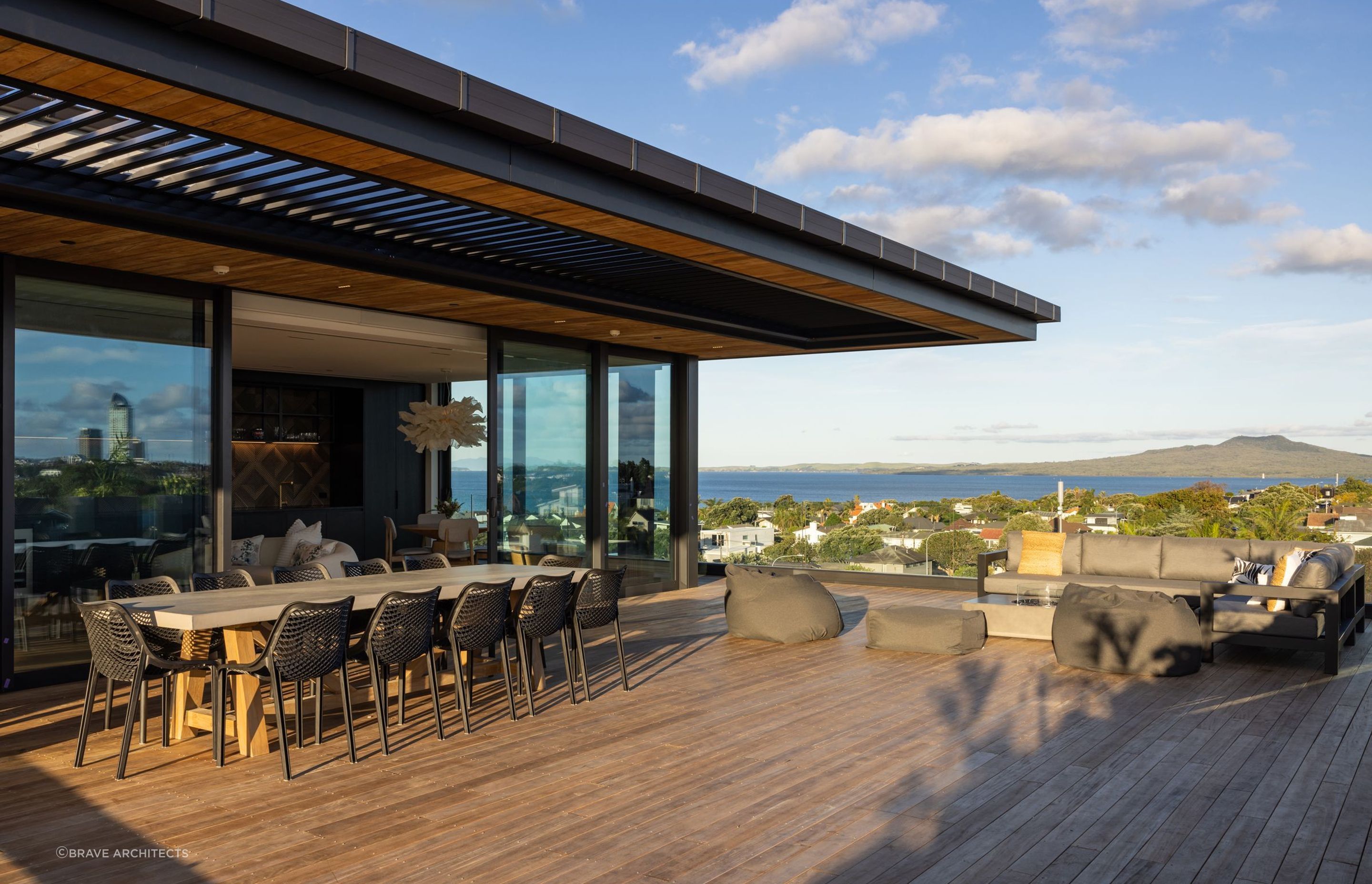 The deck is complete with plenty of seating, a fire pit, and a breathtaking view of Rangitoto.