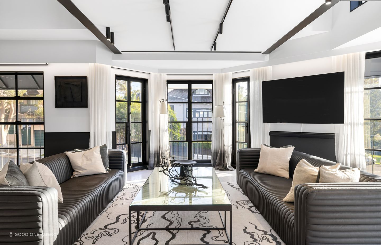 The steel joinery and track lighting provides a structured grid and rhythm in the space.