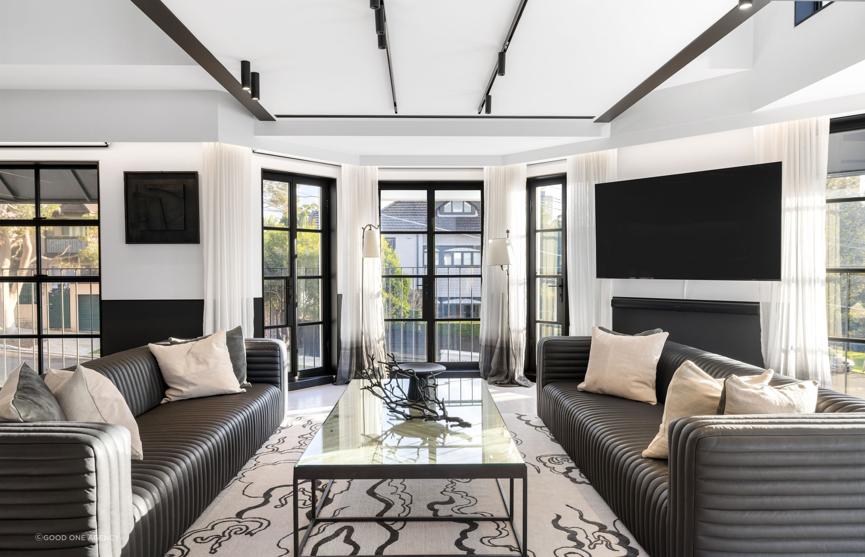 The steel joinery and track lighting provides a structured grid and rhythm in the space.