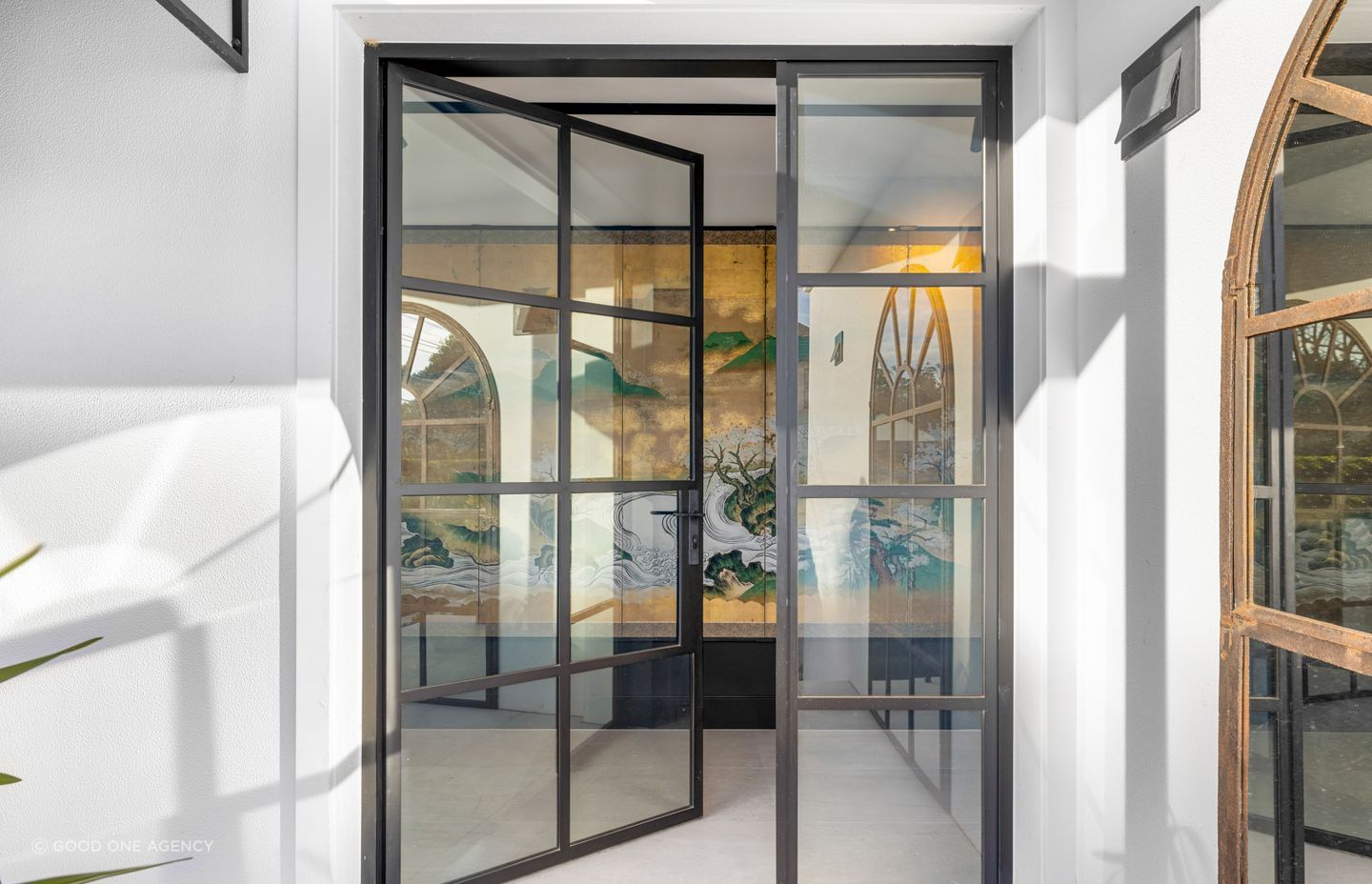 To enhance the entry to the home, an antique Japanese screen lies behind the steel entrance doors, drawing visitors in.