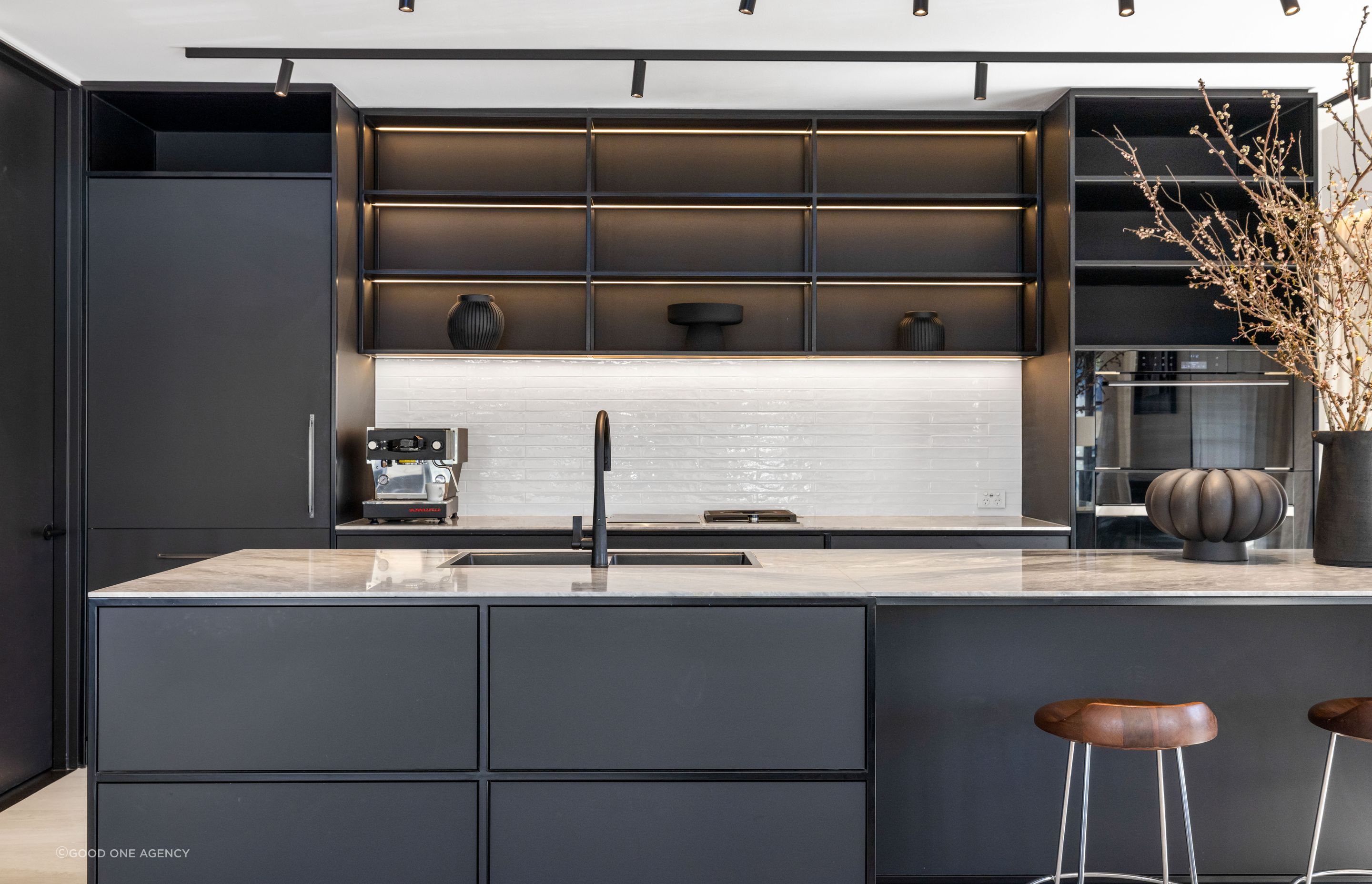 The monochromatic kitchen features black steel, tying beautifully with the steel joinery throughout the living space.