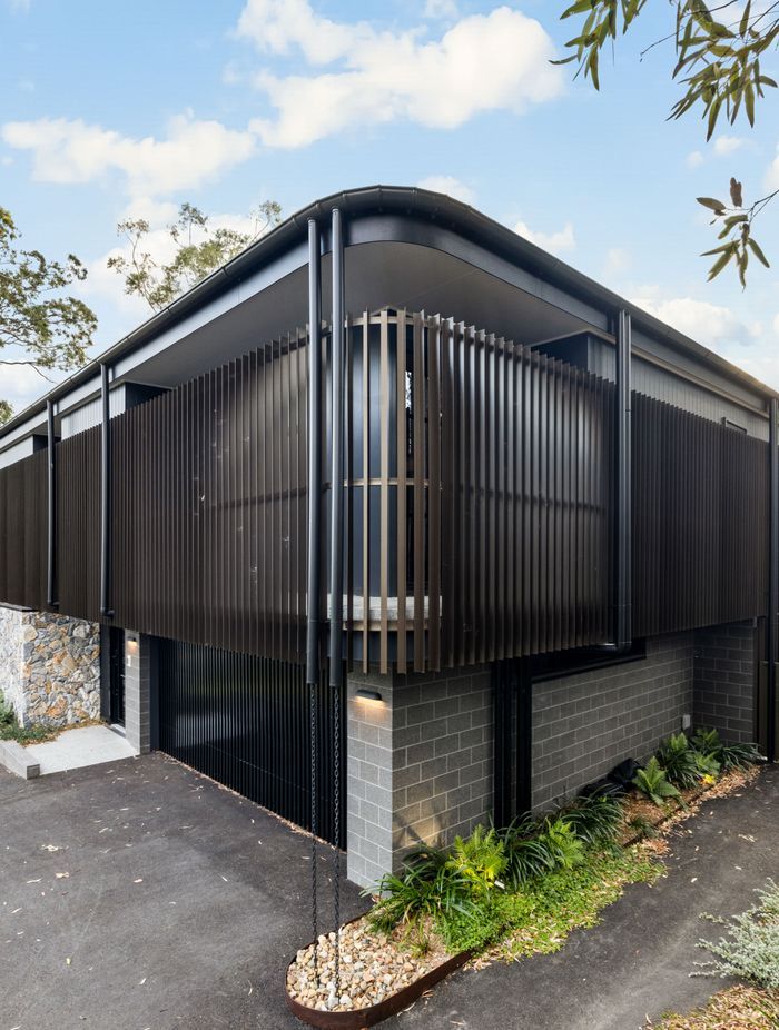 The form of the home avoids sharp lines, with the bronze coloured aluminium battens creating a soft, perforated.