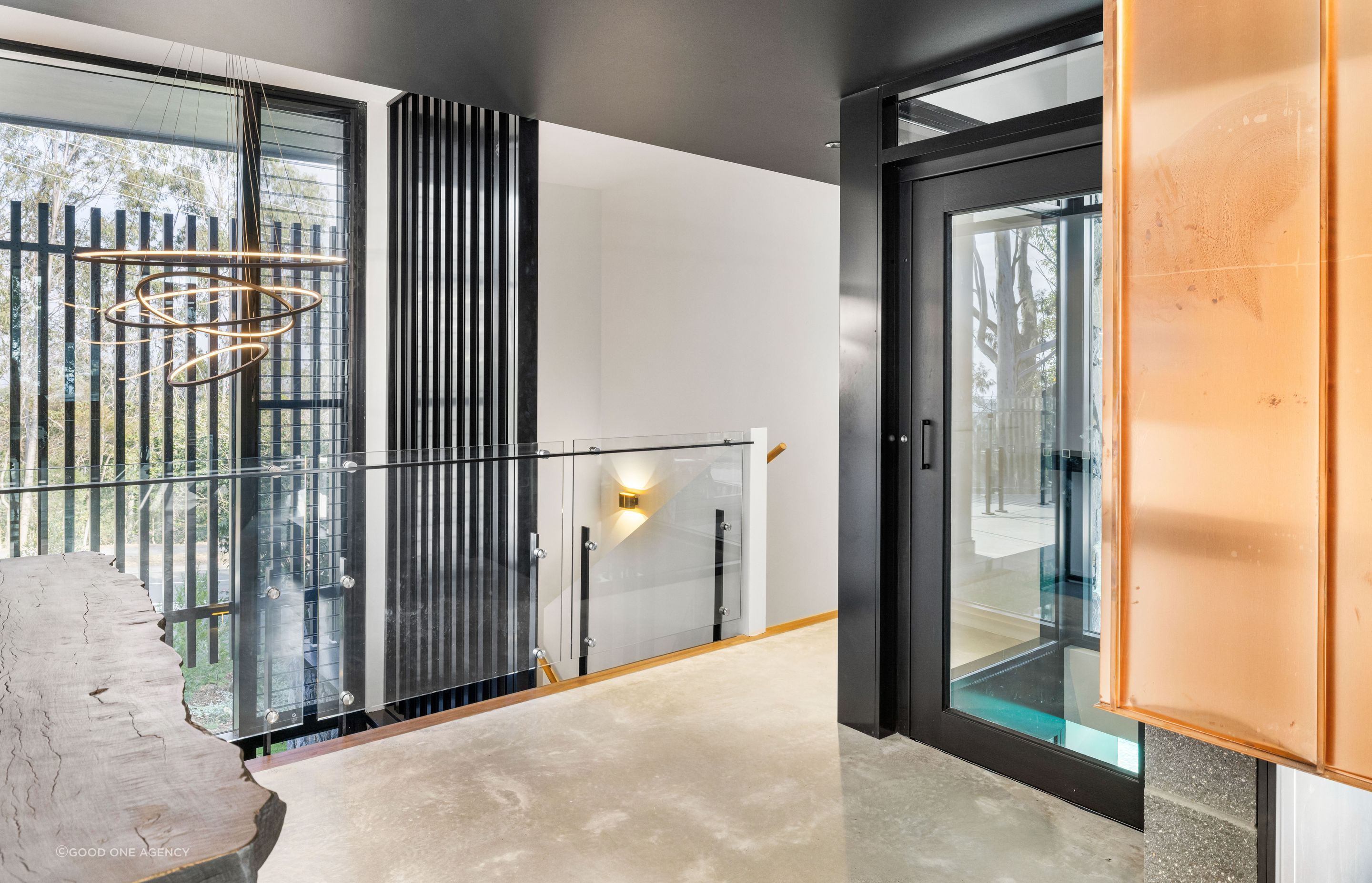 The glass lift takes in the view of the pool as it ascends.