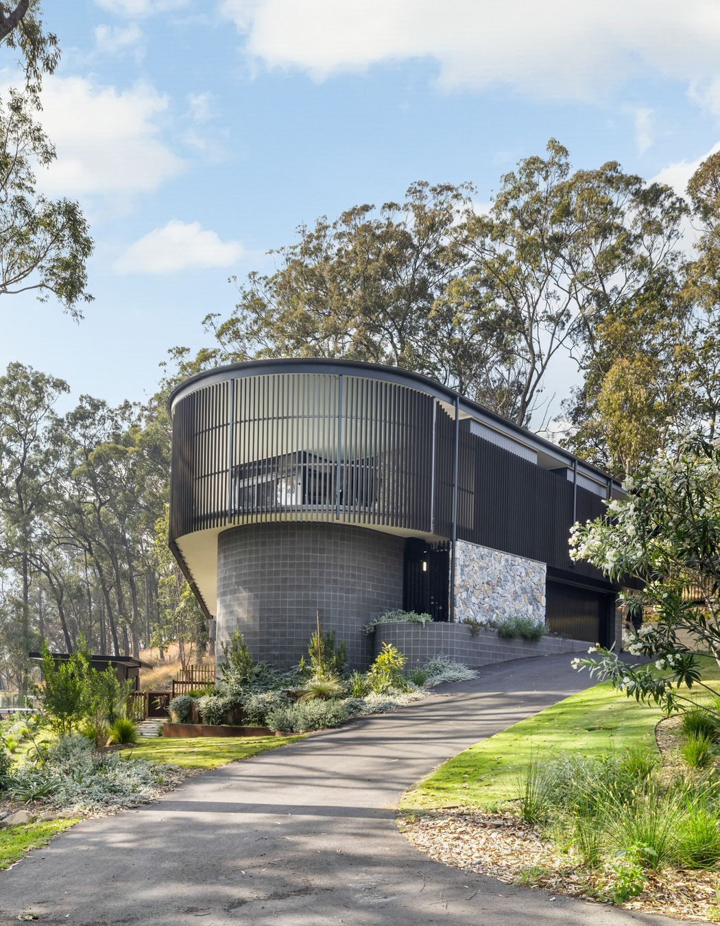 Robust materials were chosen for the exterior, including shot-blasted face blockwork, extensive glazing, and metal roofing, to fortify the structure against potential bushfire threats.