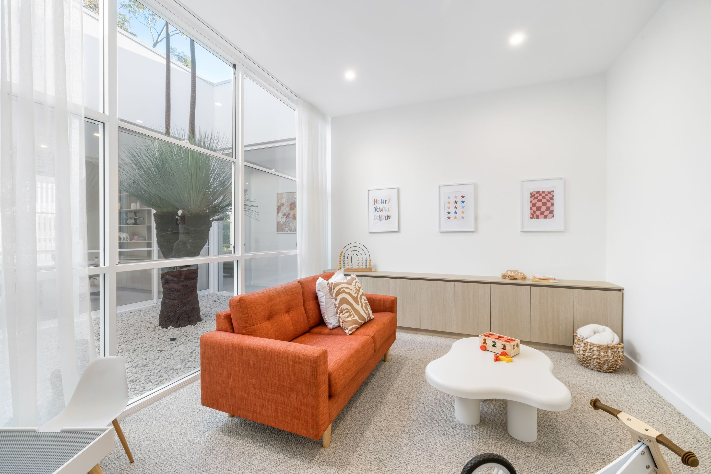 The children's playroom looks out to the central courtyard featuring the grass tree.