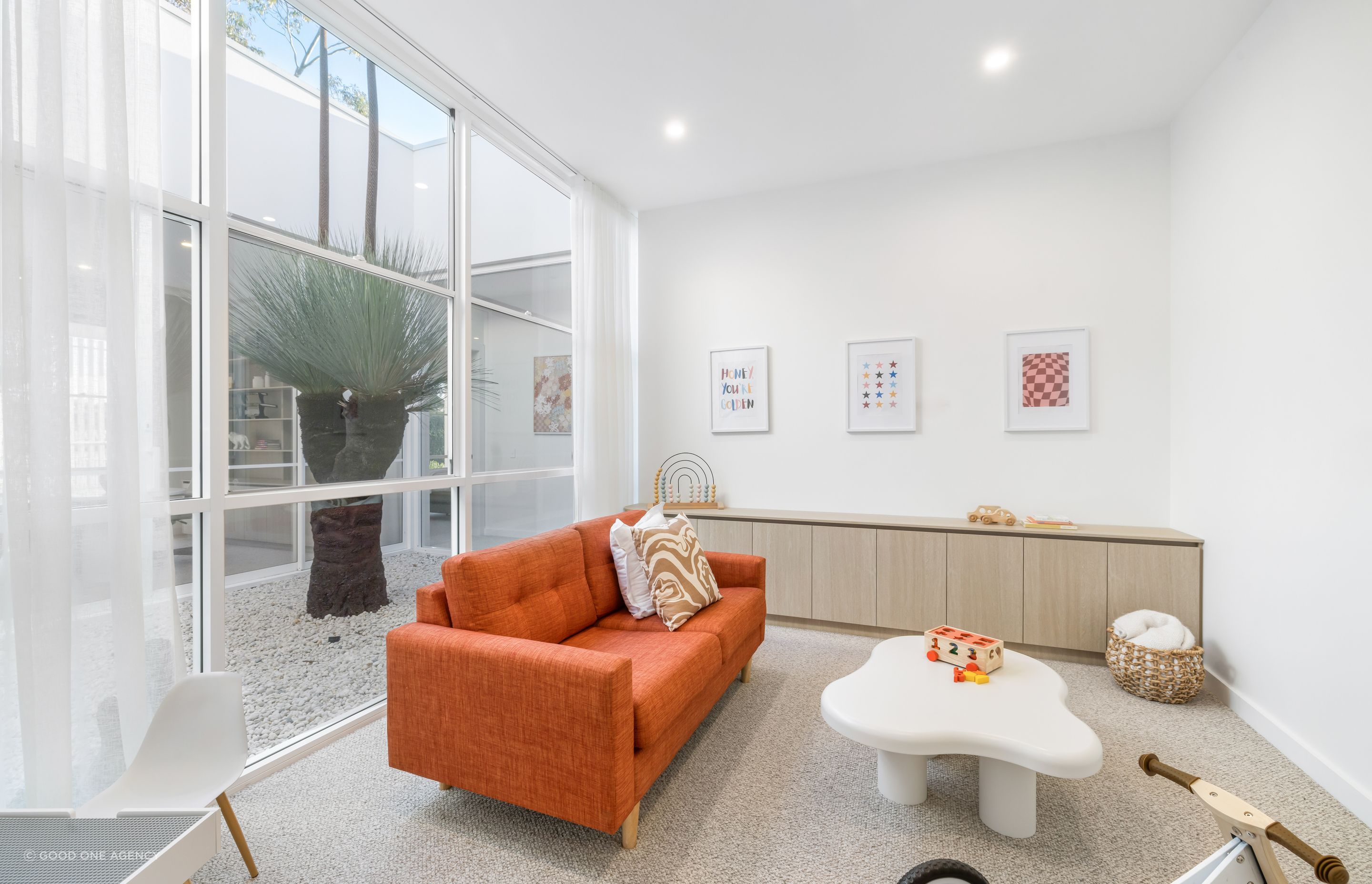 The children's playroom looks out to the central courtyard featuring the grass tree.