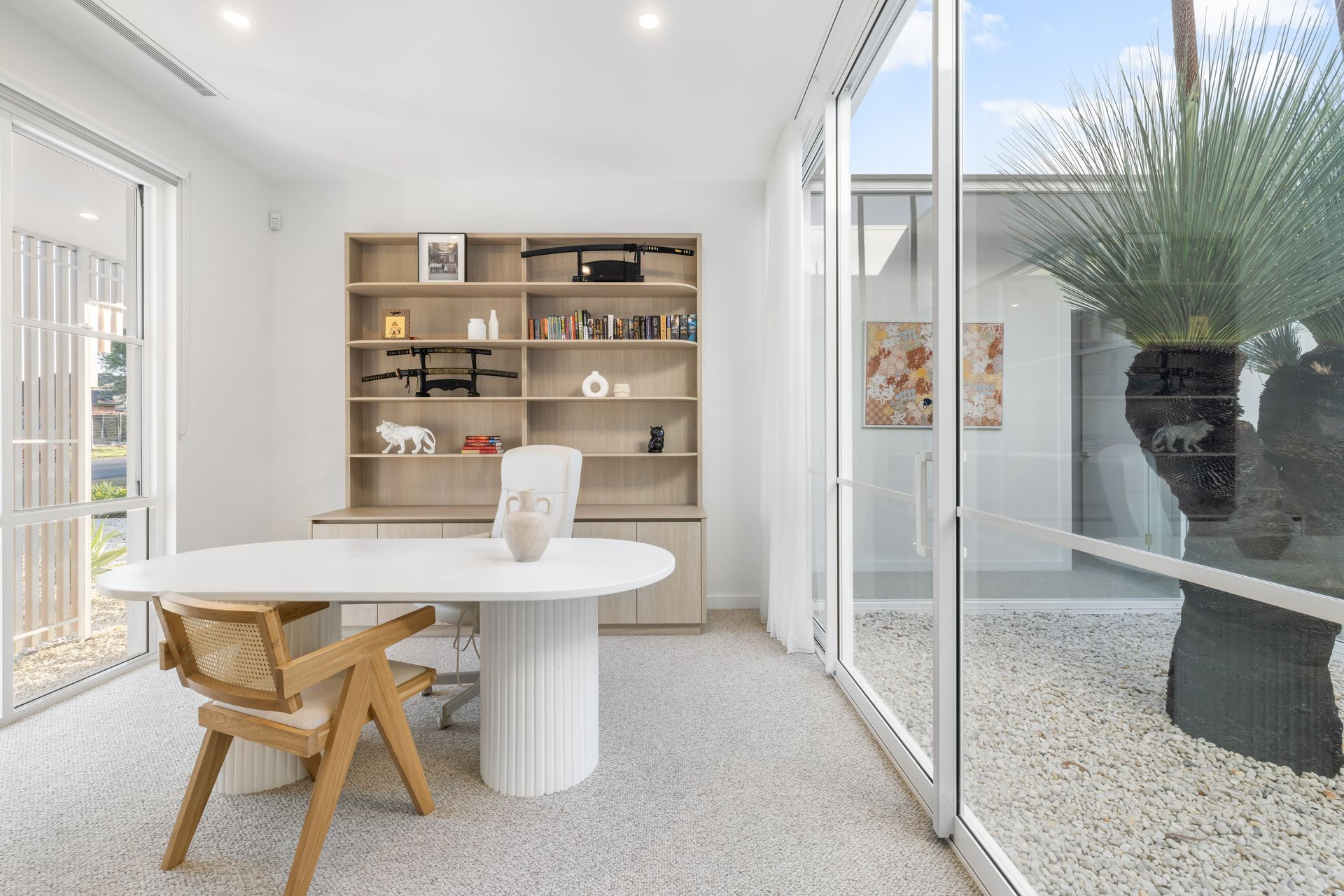 The study near the front of the house takes its light from an internal courtyard, enjoying a view of the grass tree.
