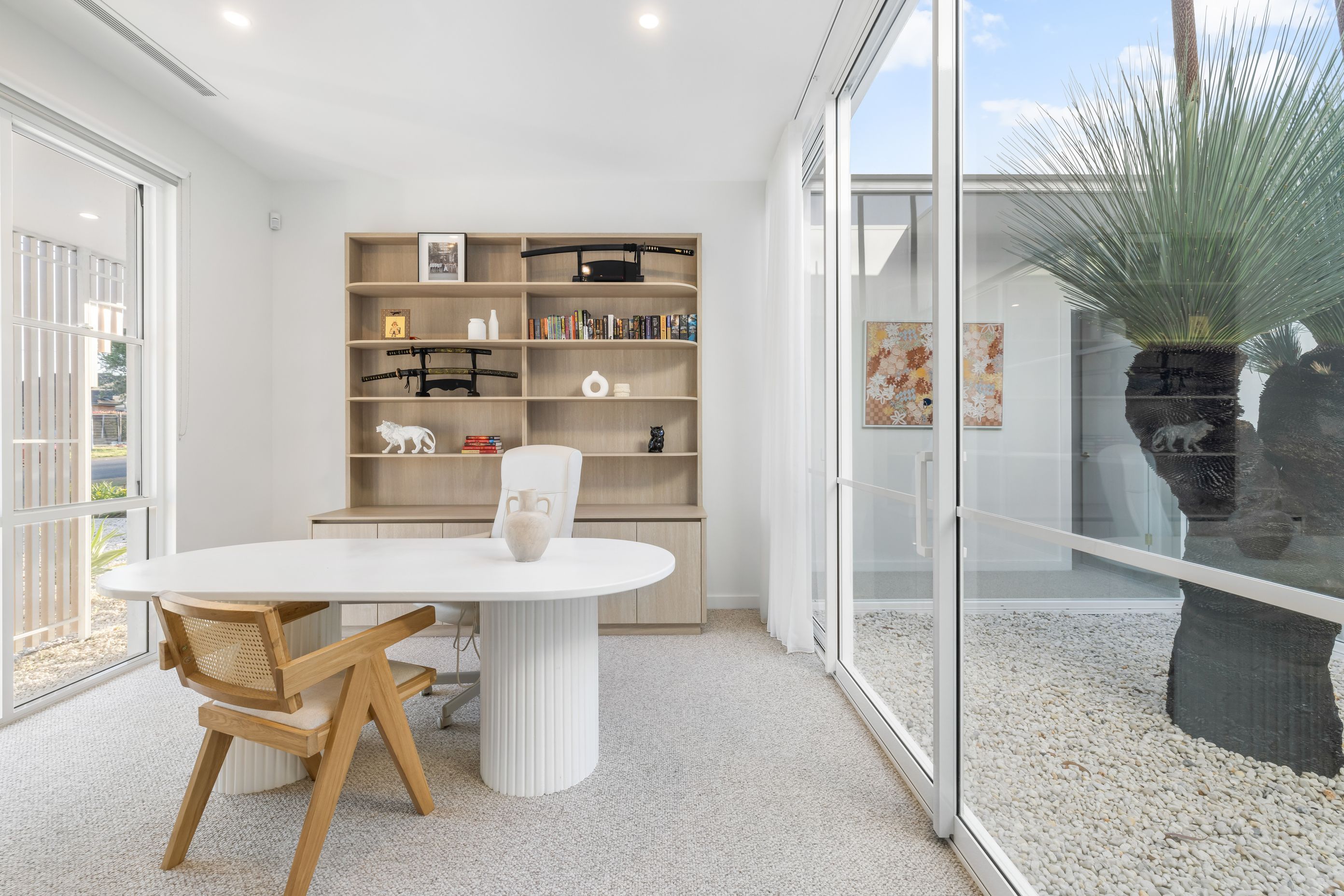 The study near the front of the house takes its light from an internal courtyard, enjoying a view of the grass tree.