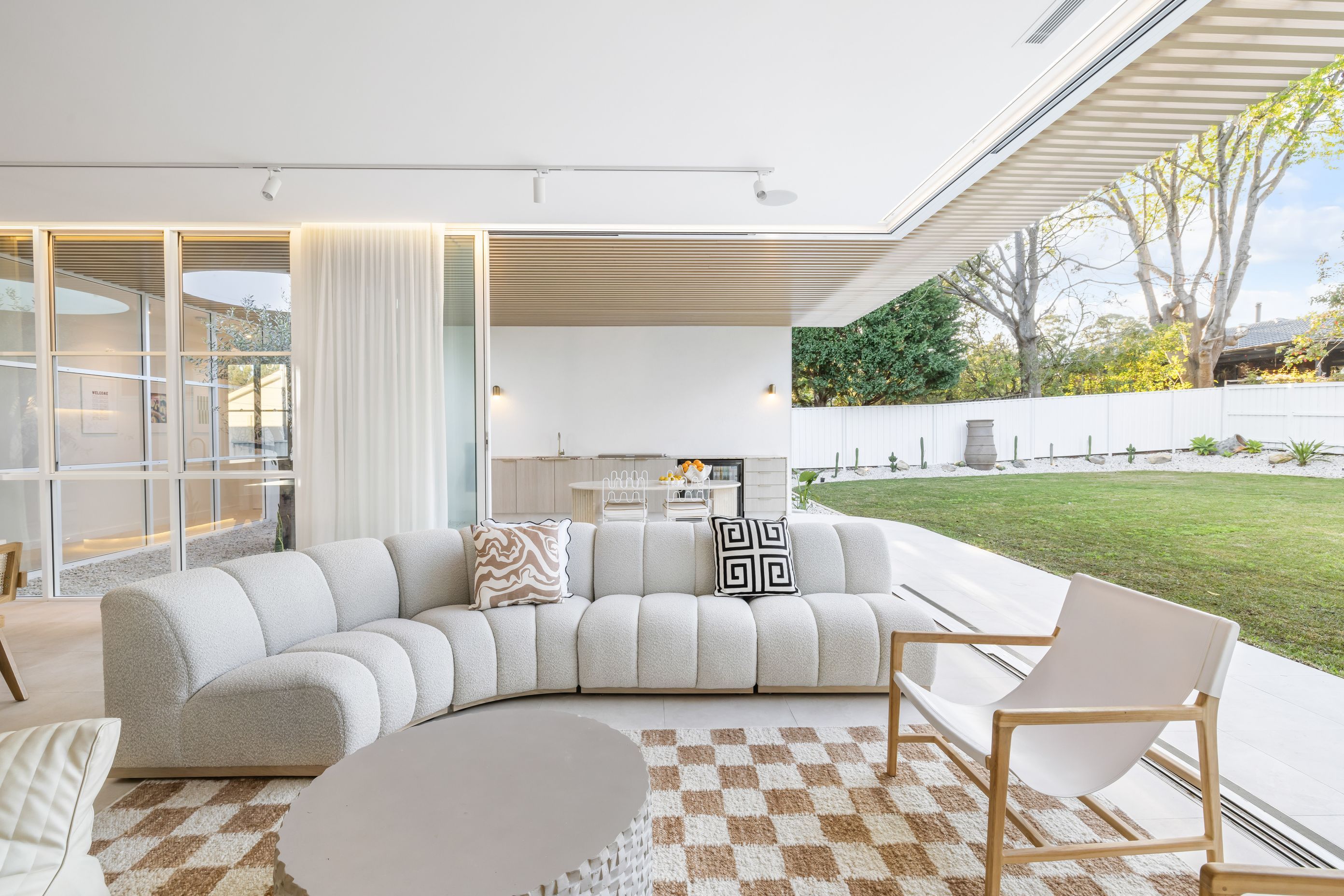 The lounge space flows seamlessly to an outdoor kitchen.