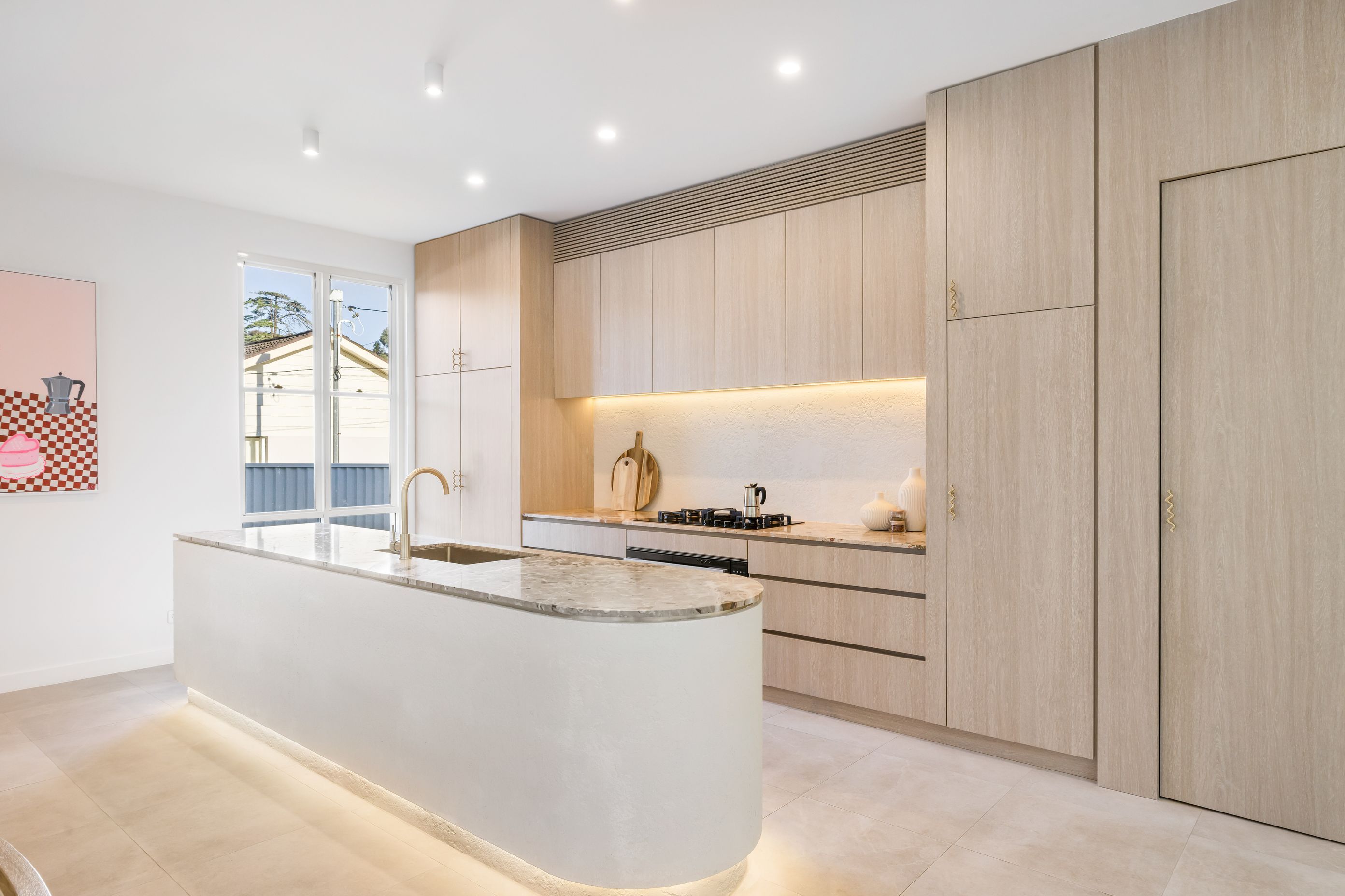 The kitchen features a pale palette and Botticelli marble benchtops.
