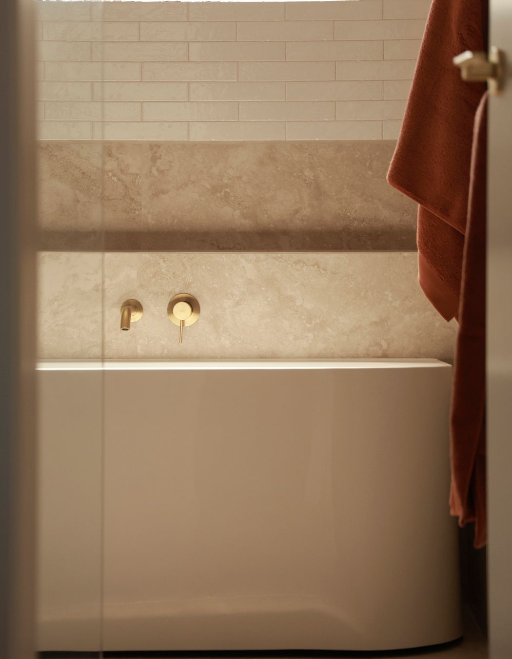 Every detail has been considered, with brass fixtures and a niche for easy reach while in the bathtub.