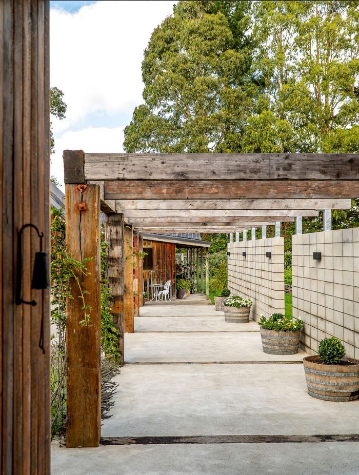 The solid timber pergola connects the house and barn.